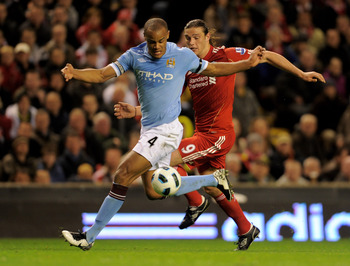 LIVERPOOL, ENGLAND - APRIL 11:  Andy Carroll of Liverpool competes with Vincent Kompany of Manchester City during the Barclays Premier League match between Liverpool and Manchester City at Anfield on April 11, 2011 in Liverpool, England.  (Photo by Michae