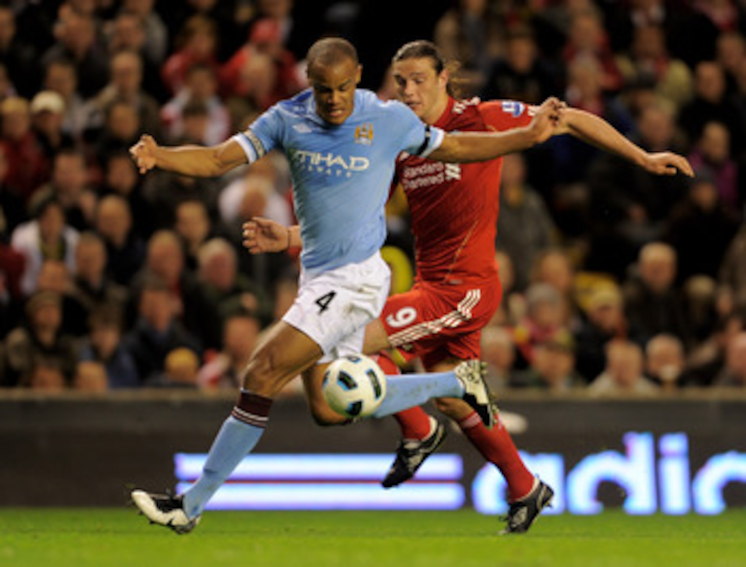 LIVERPOOL, ENGLAND - APRIL 11:  Andy Carroll of Liverpool competes with Vincent Kompany of Manchester City during the Barclays Premier League match between Liverpool and Manchester City at Anfield on April 11, 2011 in Liverpool, England.  (Photo by Michae