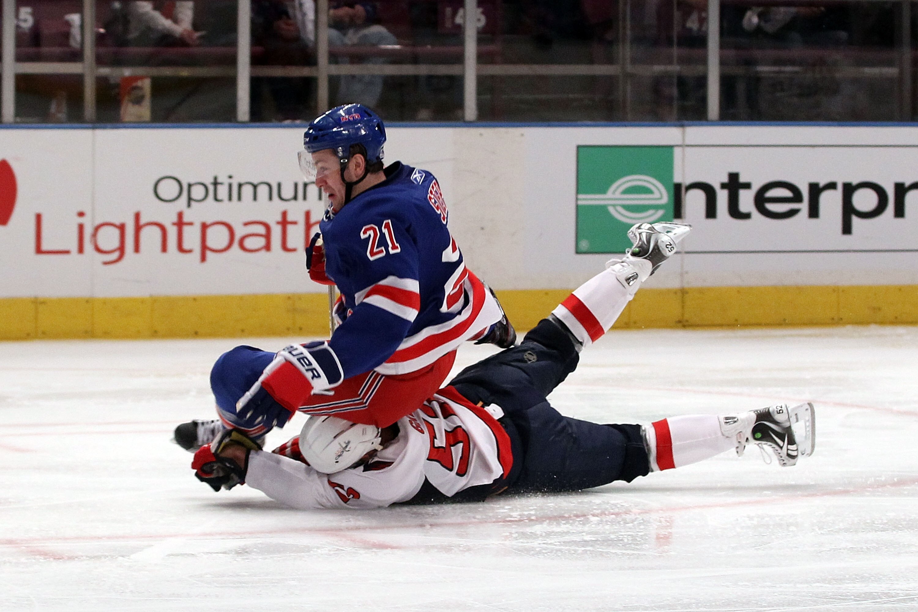 NEW YORK, NY - APRIL 20:  Derek Stepan #21 of the New York Rangers falls to the ice as he was tripped up by Mike Green #52 of the Washington Capitals in Game Four of the Eastern Conference Quarterfinals during the 2011 NHL Stanley Cup Playoffs at Madison