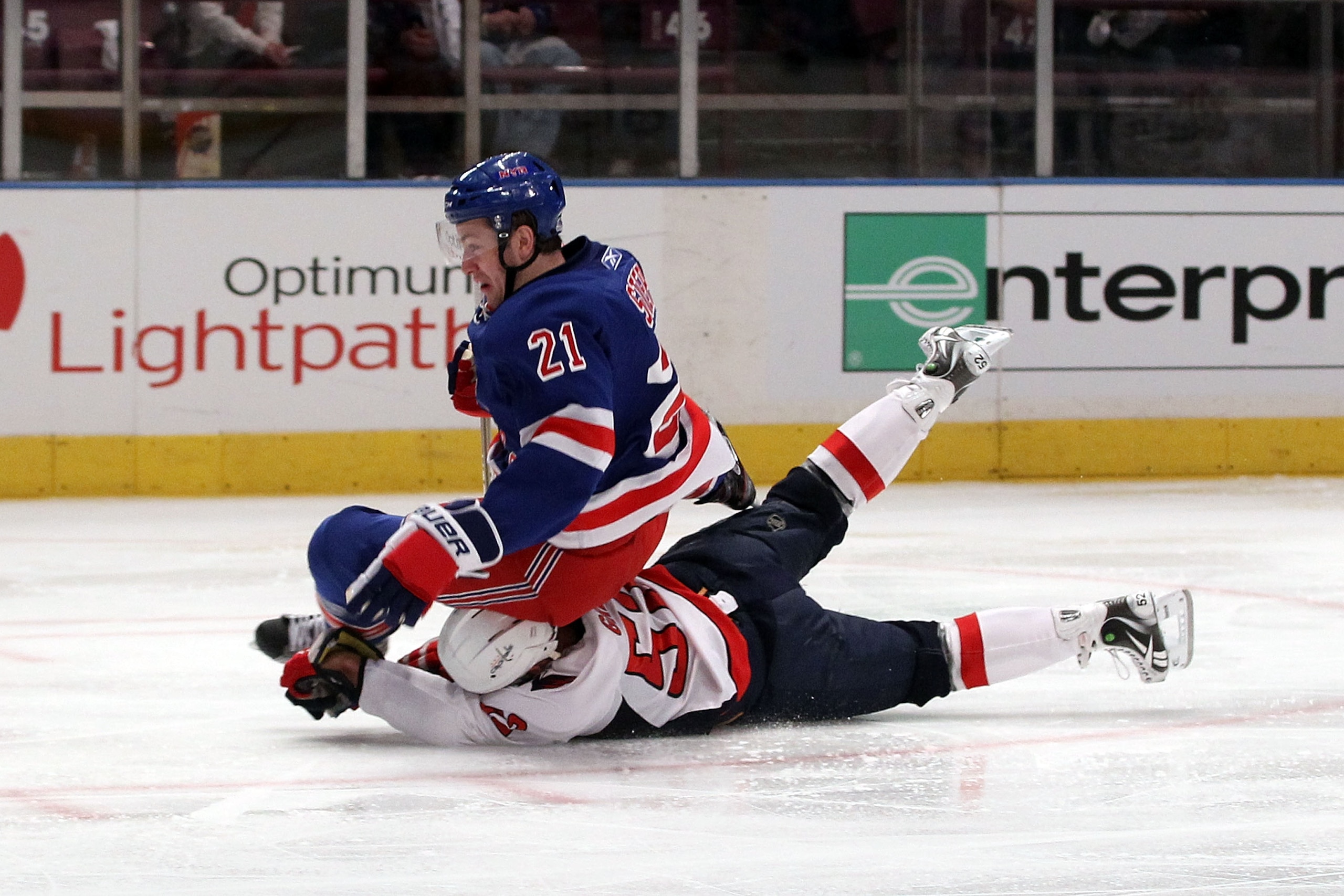 NEW YORK, NY - APRIL 20:  Derek Stepan #21 of the New York Rangers falls to the ice as he was tripped up by Mike Green #52 of the Washington Capitals in Game Four of the Eastern Conference Quarterfinals during the 2011 NHL Stanley Cup Playoffs at Madison