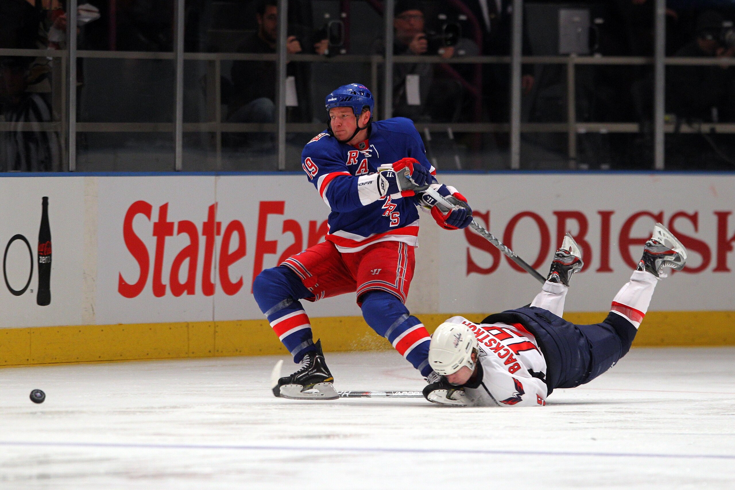 NEW YORK, NY - APRIL 20:  Ruslan Fedotenko #19 of the New York Rangers is tripped up by Nicklas Backstrom #19 of the Washington Capitals in Game Four of the Eastern Conference Quarterfinals during the 2011 NHL Stanley Cup Playoffs at Madison Square Garden