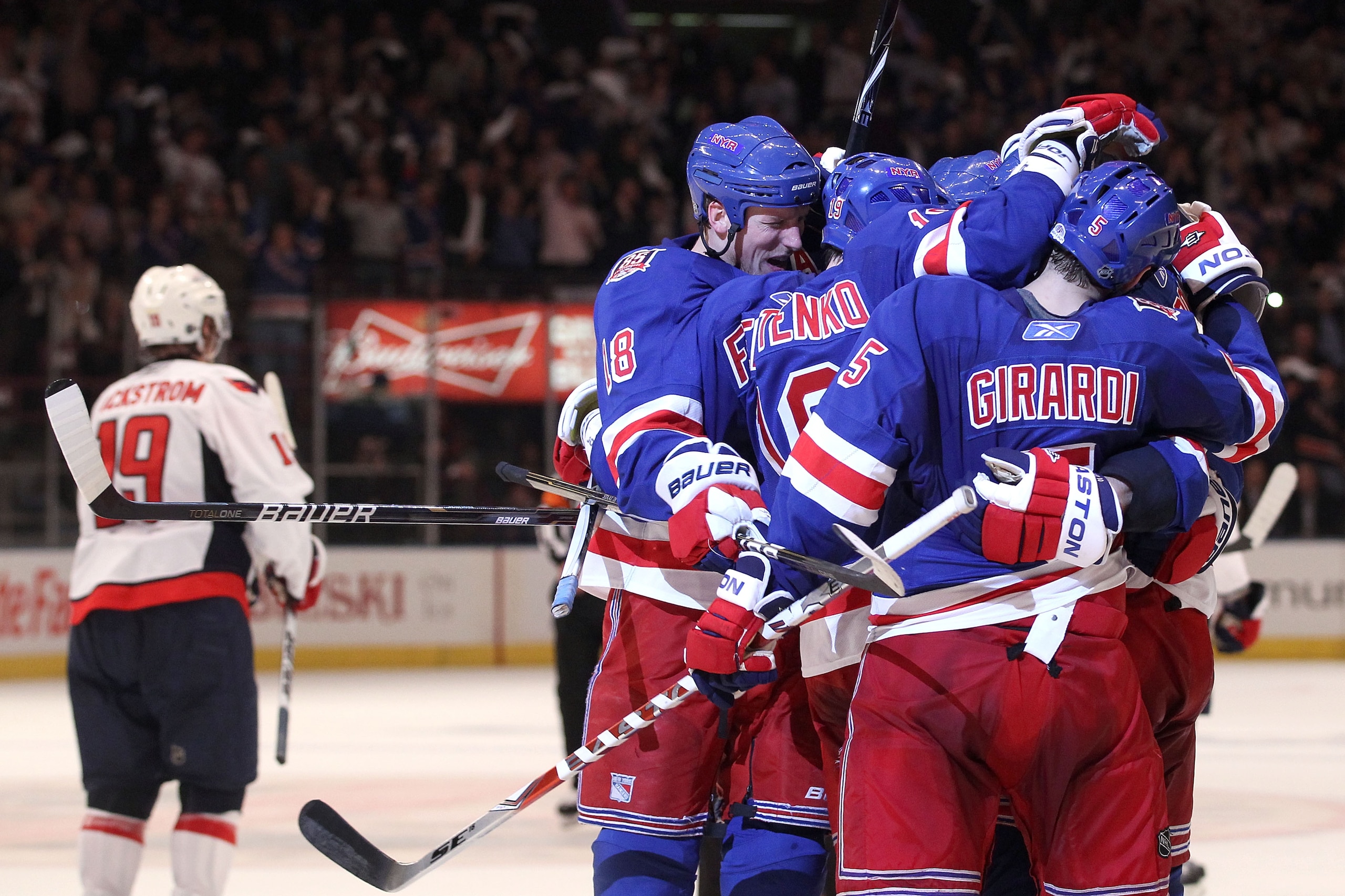 NEW YORK, NY - APRIL 20:  The New York Rangers celebrate after Brandon Dubinsky #17 scored a second period goal as Nicklas Backstrom #19 of the Washington Capitals skates off in Game Four of the Eastern Conference Quarterfinals during the 2011 NHL Stanley