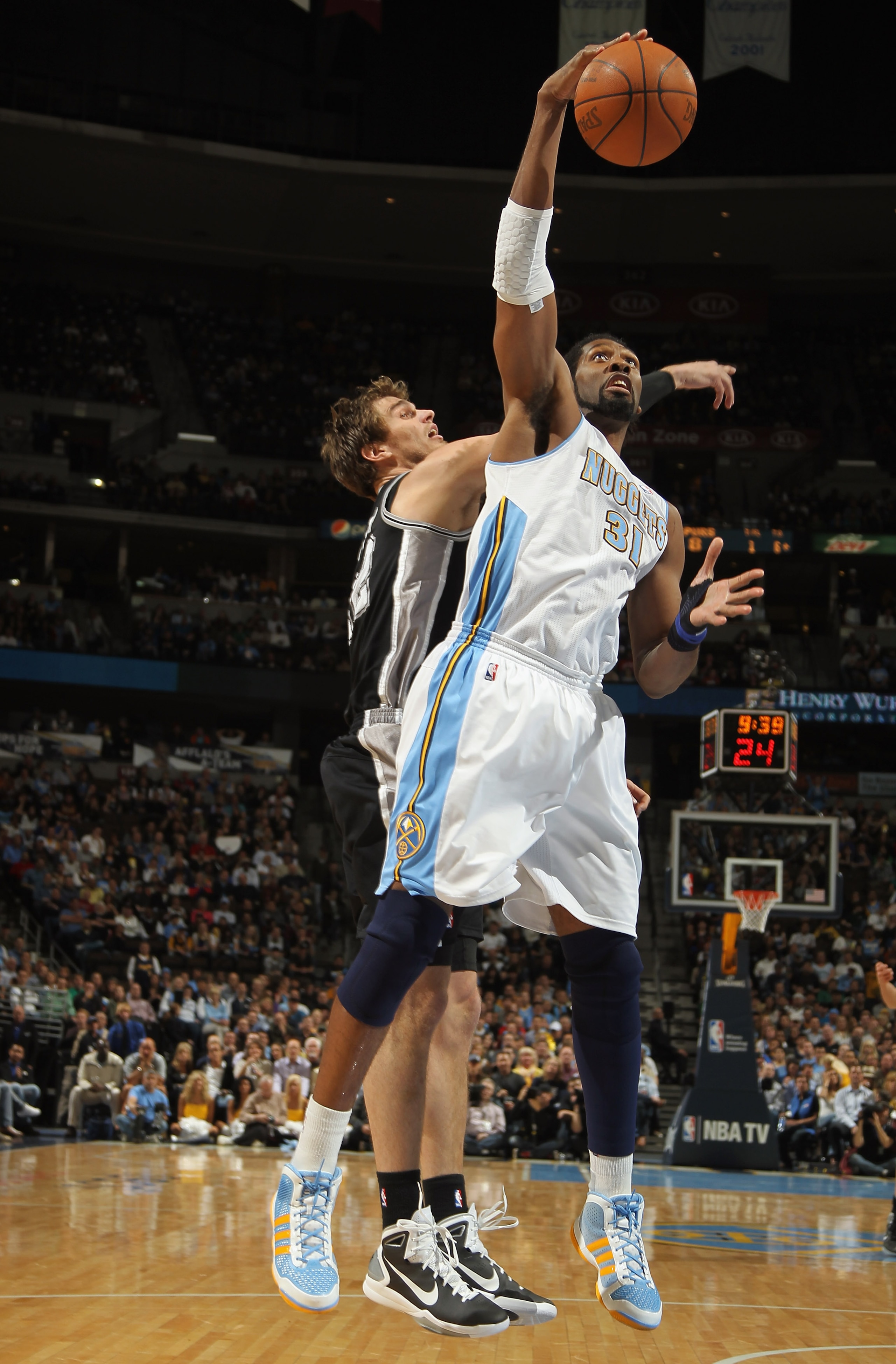 DENVER, CO - MARCH 23:  Nene #31 of the Denver Nuggets grabs a rebound away from Tiago Splitter #22 at the Pepsi Center on March 23, 2011 in Denver, Colorado. The Nuggets defeated the Spurs 115-112. NOTE TO USER: User expressly acknowledges and agrees tha