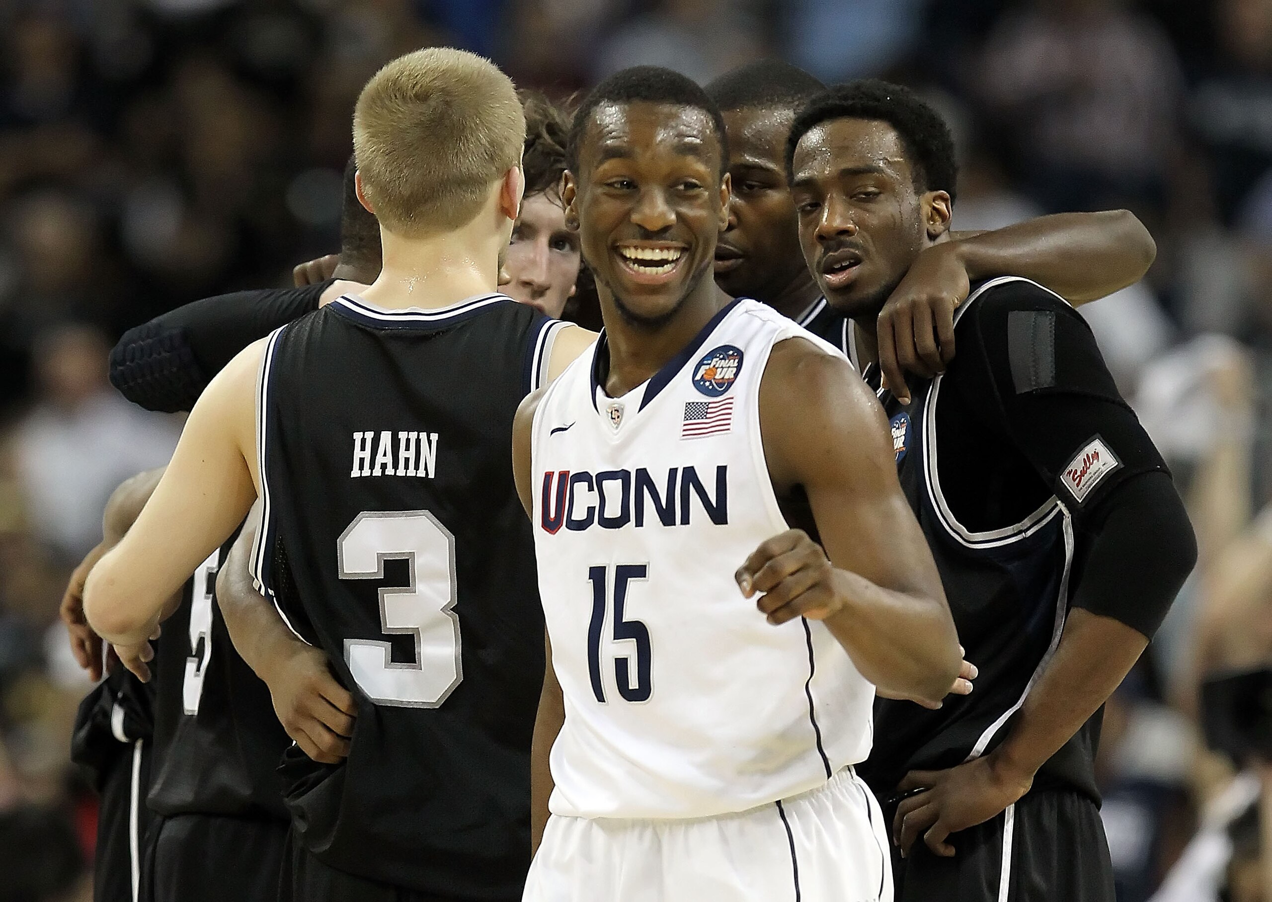 HOUSTON, TX - APRIL 04:  Kemba Walker #15 of the Connecticut Huskies smiles as the Butler Bulldogs huddle during the National Championship Game of the 2011 NCAA Division I Men's Basketball Tournament at Reliant Stadium on April 4, 2011 in Houston, Texas.