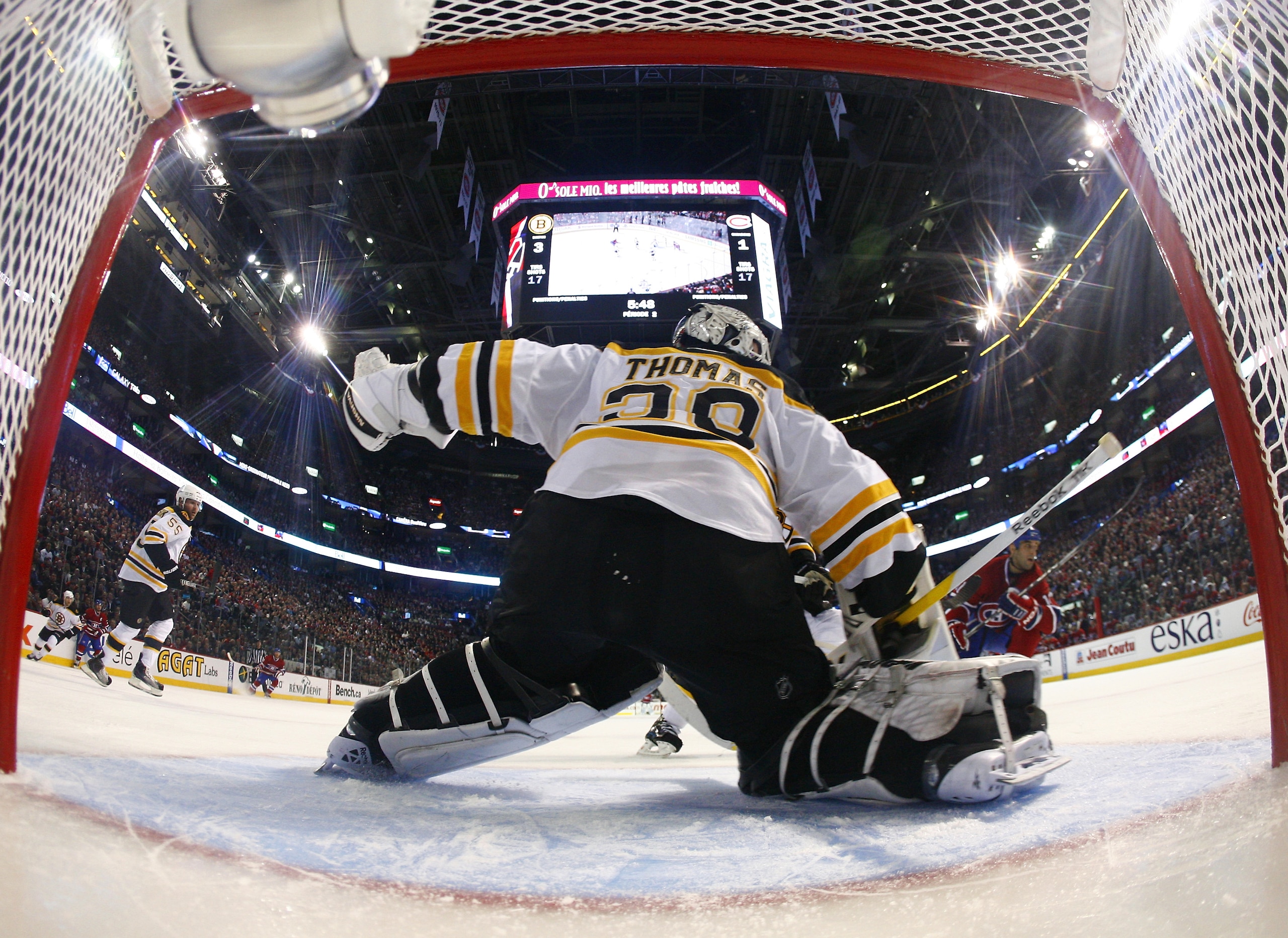 MONTREAL, CANADA - APRIL 18:  Tim Thomas #30 of the Boston Bruins slides from post to post after a save while Scott Gomez #11 of the Montreal Canadiens skates after the rebound in Game Three of the Eastern Conference Quarterfinals during the 2011 NHL Stan