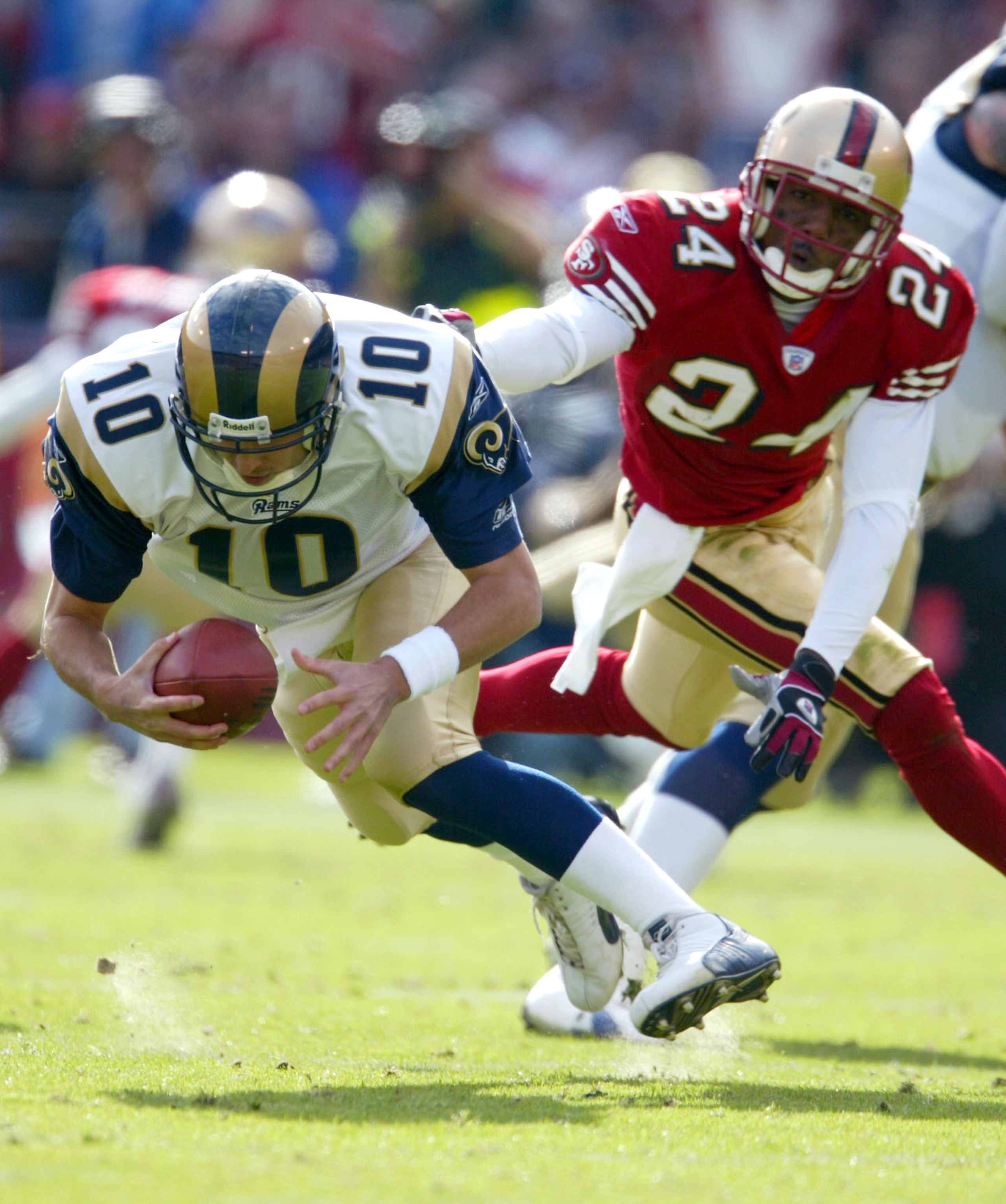 SAN FRANCISCO - NOVEMBER 2:  Marc Bulger #10 of the St. Louis Rams is rushed by Mike Rumph #24 of the San Francisco 49ers during an NFL game on November 2, 2003 at Candlestick Park in San Francisco, California.  (Photo by Jed Jacobsohn/Getty Images)