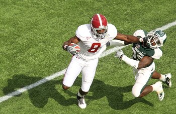 ORLANDO, FL - JANUARY 01: Julio Jones #8 of the Alabama Crimson Tide stiffarms Chris Rucker #29 of  the Michigan State Spartans during the Capitol One Bowl at the Florida Citrus Bowl on January 1, 2011 in Orlando, Florida.  (Photo by Mike Ehrmann/Getty Im