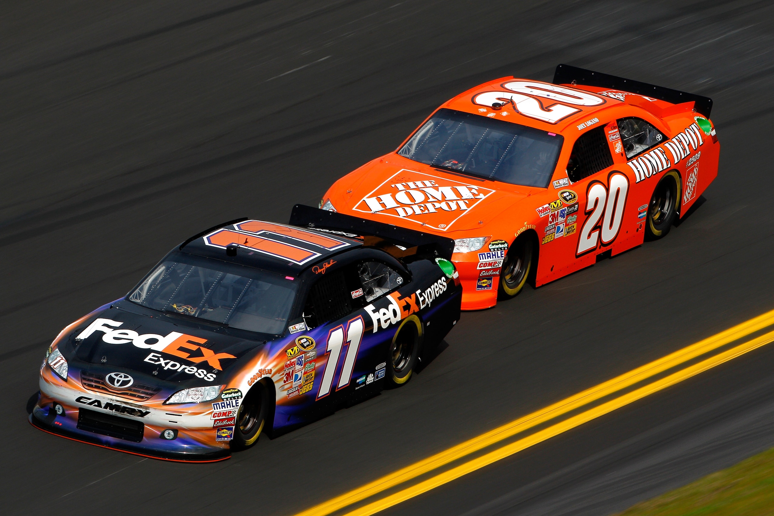 DAYTONA BEACH, FL - FEBRUARY 16:  Denny Hamlin, driver of the #11 FedEx Toyota, leads Joey Logano, driver of the #20 Home Depot Toyota, during practice for the NASCAR Sprint Cup Series Daytona 500 at Daytona International Speedway on February 16, 2011 in
