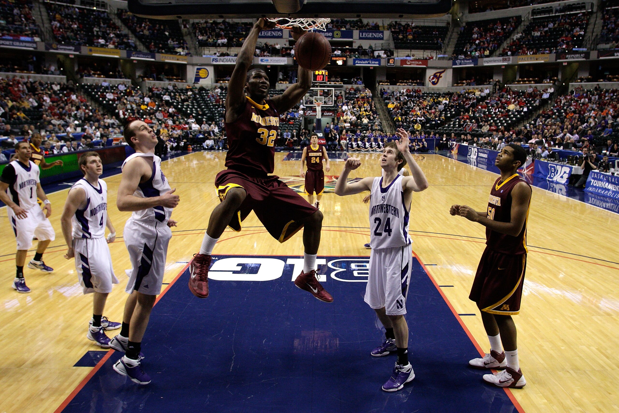 INDIANAPOLIS, IN - MARCH 10:  Trevor Mbakwe #32 of the Minnesota Golden Gophers dunks against John Shurna #24 of the Northwestern Wildcats during the first round of the 2011 Big Ten Men's Basketball Tournament at Conseco Fieldhouse on March 10, 2011 in In