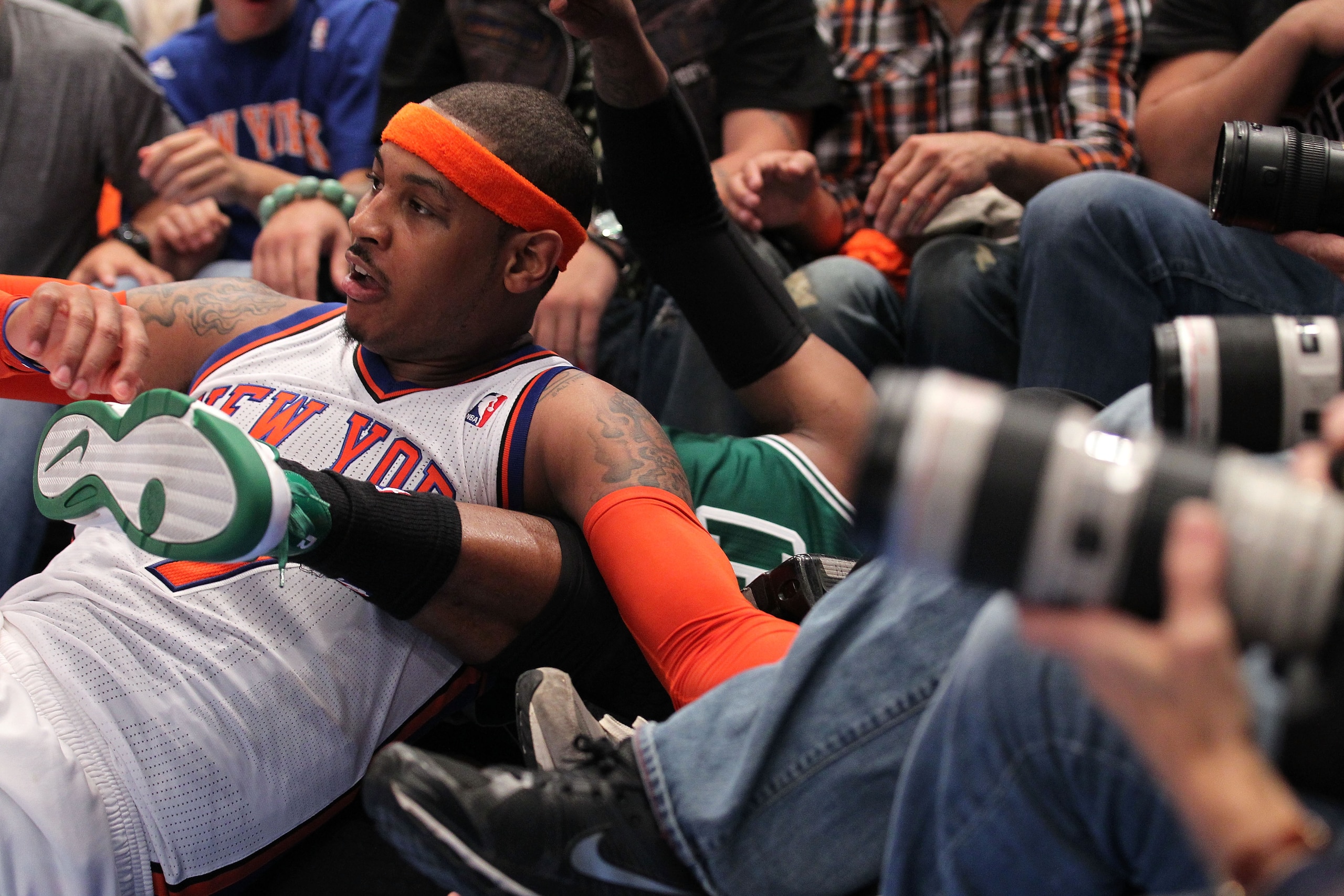 NEW YORK, NY - APRIL 24:  Carmelo Anthony #7 of the New York Knicks and Paul Pierce #34 of the Boston Celtics fall into photographers row on the baseline in Game Four of the Eastern Conference Quarterfinals during the 2011 NBA Playoffs on April 24, 2011 a
