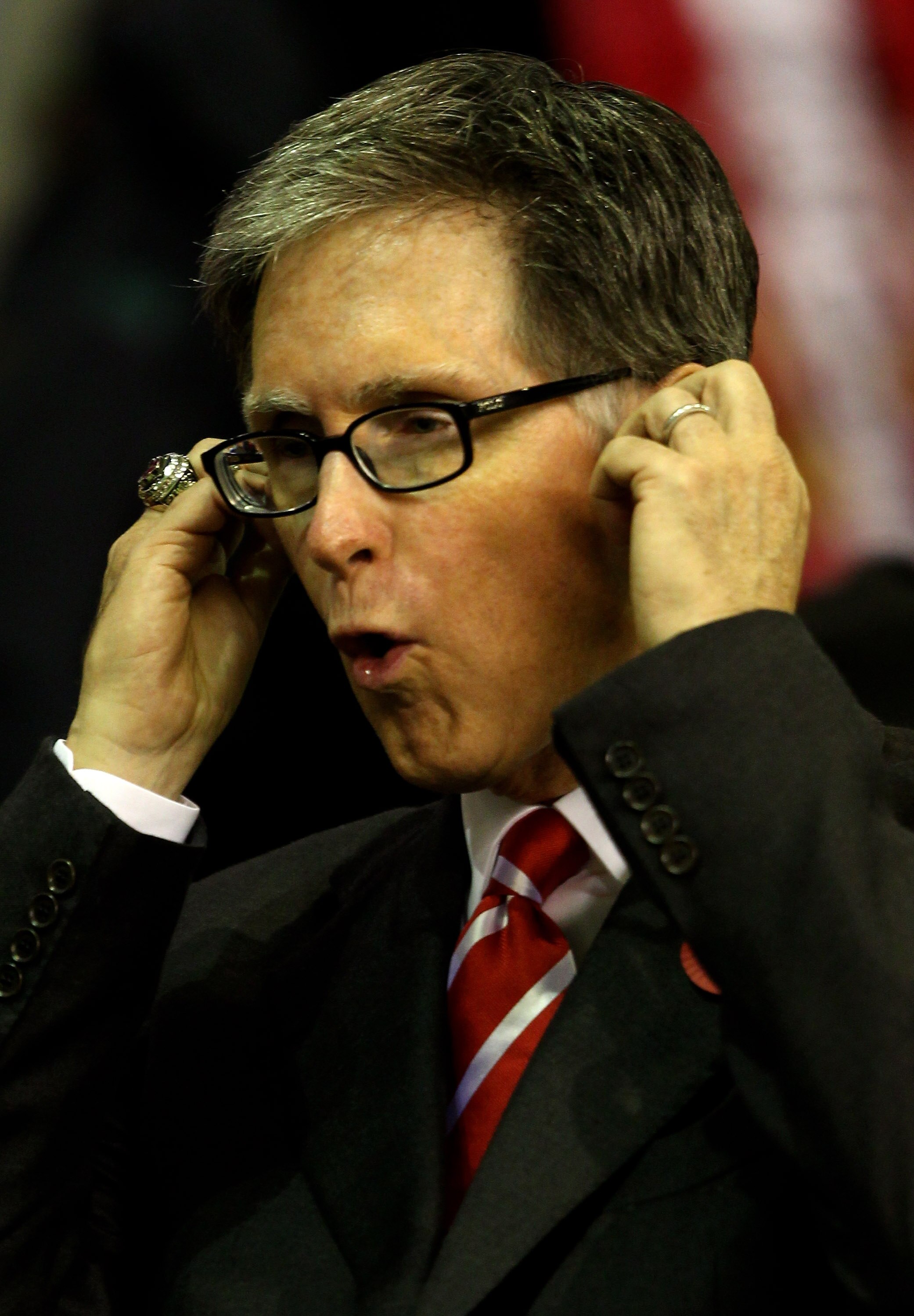 LIVERPOOL, ENGLAND - NOVEMBER 04:  Liverpool Owner John Henry puts his fingers in his ears prior to the UEFA Europa League Group K match beteween Liverpool and SSC Napoli at Anfield on November 4, 2010 in Liverpool, England.  (Photo by Clive Brunskill/Get