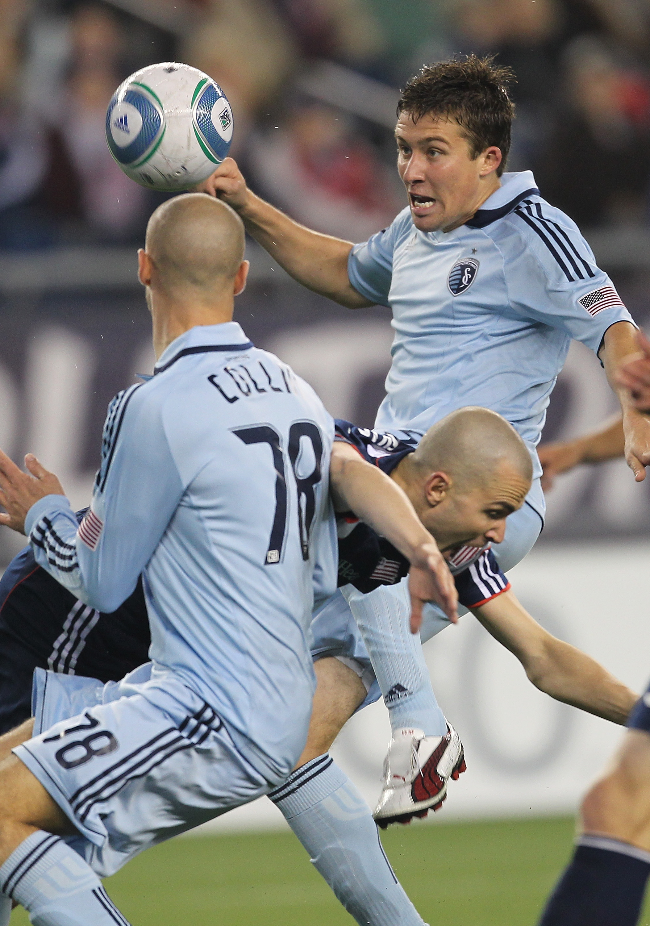 FOXBORO, MA - APRIL 23: Rajko Lekic #10 of the New England Revolution forces his way by defender Matt Besler #5 and Aurelien Collin #78 of the Sporting Kansas City at Gillette Stadium on April 23, 2011 in Foxboro, Massachusetts. Lekic would score the ga