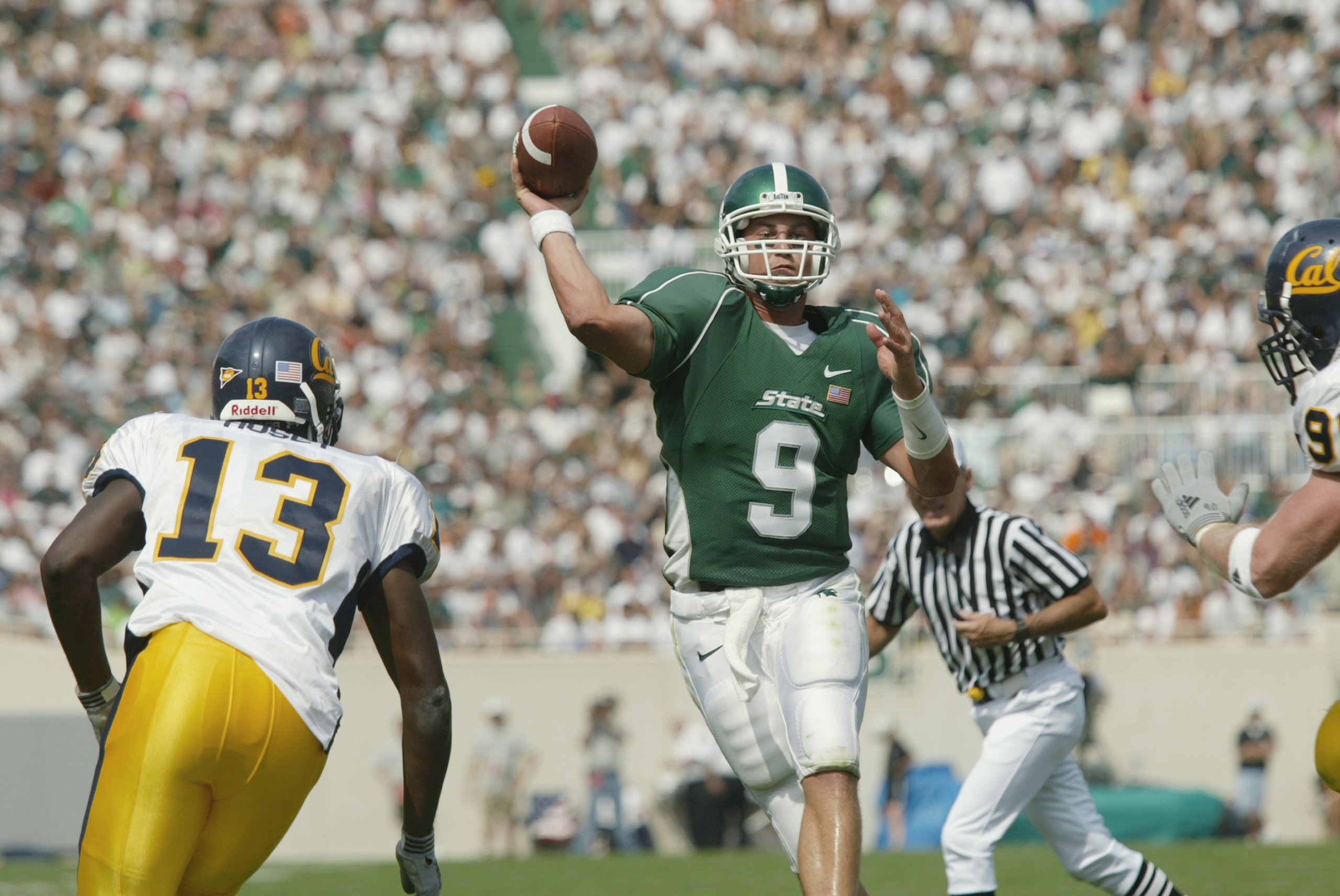 EAST LANSING, MI - SEPTEMBER 14:  Quarterback Jeff Smoker #9 of the Michigan State Spartans throws a pass as linebacker Calvin Hosey #13 of the California Golden Bears applies pressure on September 14, 2002 at Spartan Stadium in East Lansing, Michigan.  C