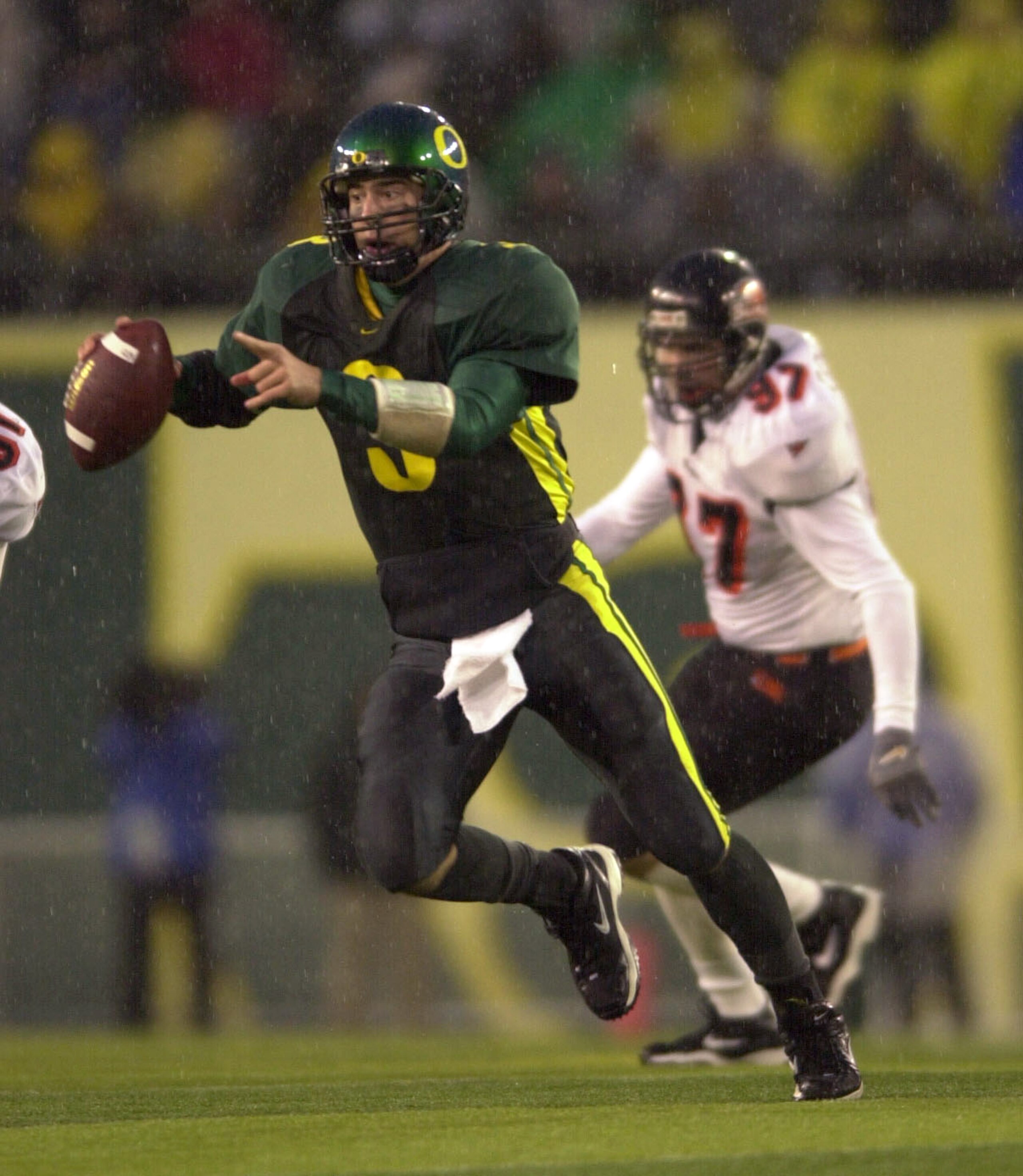 01 Dec 2001:  Quarterback Joey Harrington #3 of the Oregon Ducks looks for a receiver while being persued by Kyle Rosselle #97 of the Oregon State Beavers during second half action at Autzen Stadium in Eugene, Oregon. The Ducks defeated the Beavers 17-14.