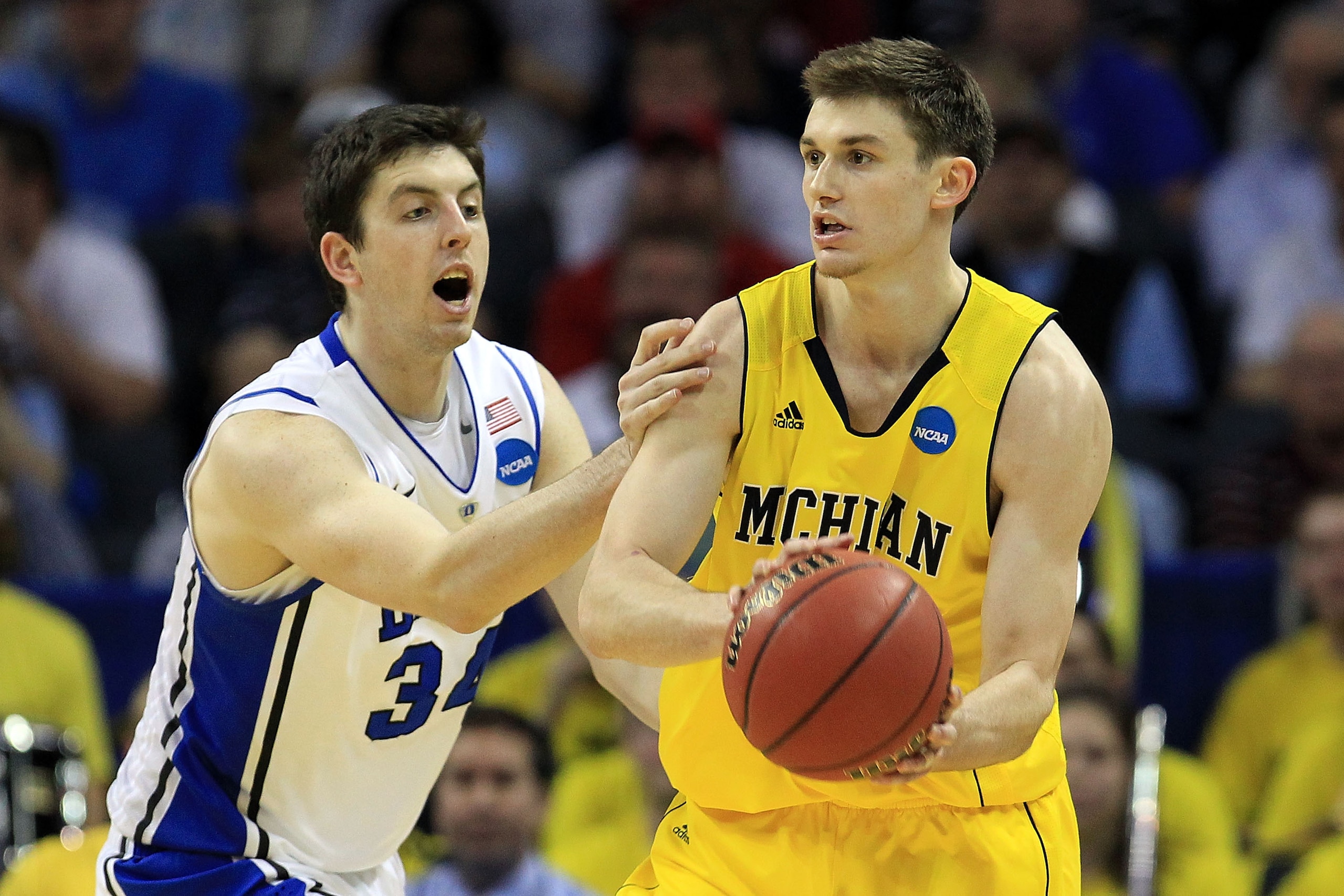 CHARLOTTE, NC - MARCH 20:  Stu Douglass #1 of the Michigan Wolverines looks to pass around Ryan Kelly #34 of the Duke Blue Devils during the third round of the 2011 NCAA men's basketball tournament at Time Warner Cable Arena on March 20, 2011 in Charlotte