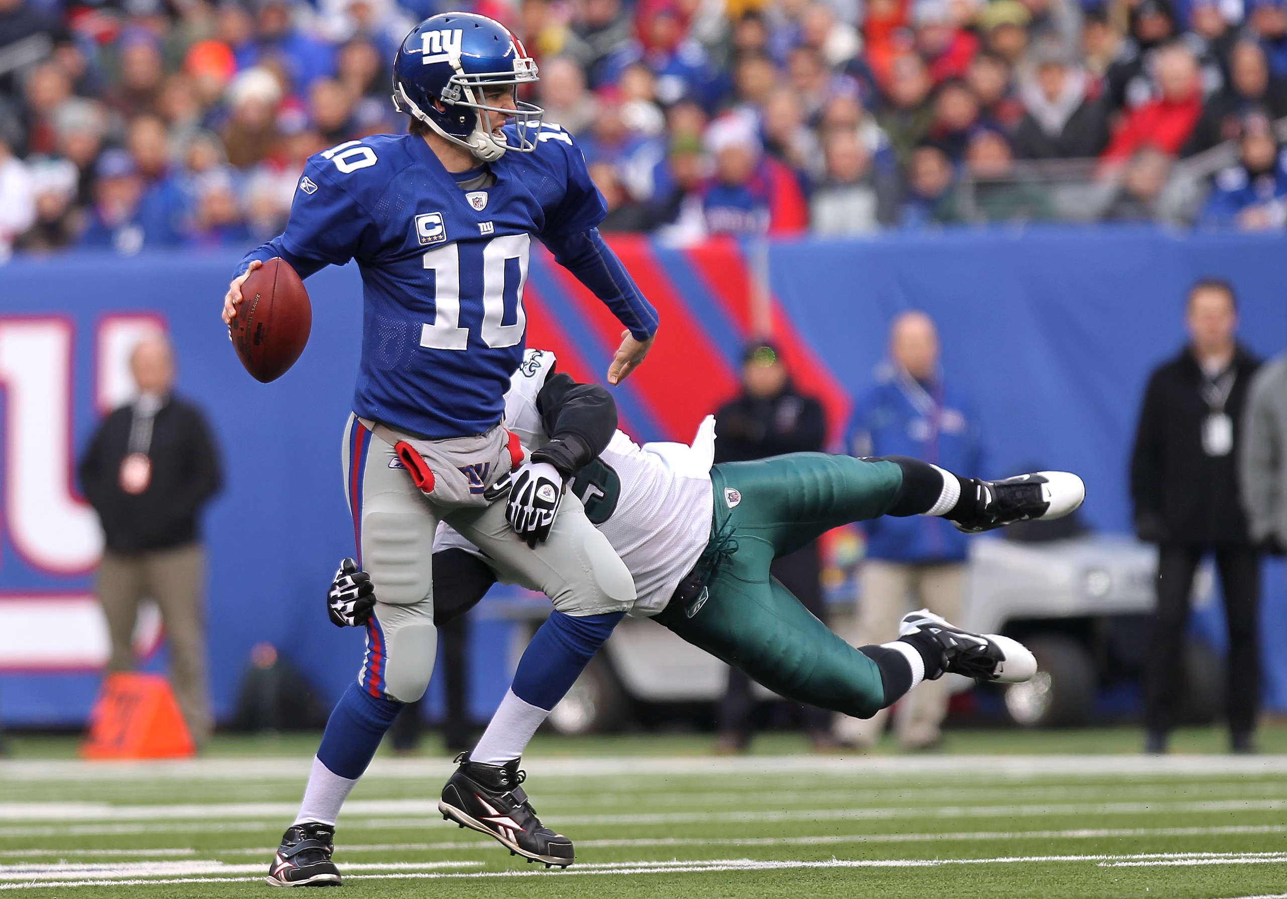 EAST RUTHERFORD, NJ - DECEMBER 19:  Eli Manning #10 of the New York Giants is sacked by Moise Fokou #53 of the Philadelphia Eagles at New Meadowlands Stadium on December 19, 2010 in East Rutherford, New Jersey.  (Photo by Nick Laham/Getty Images)