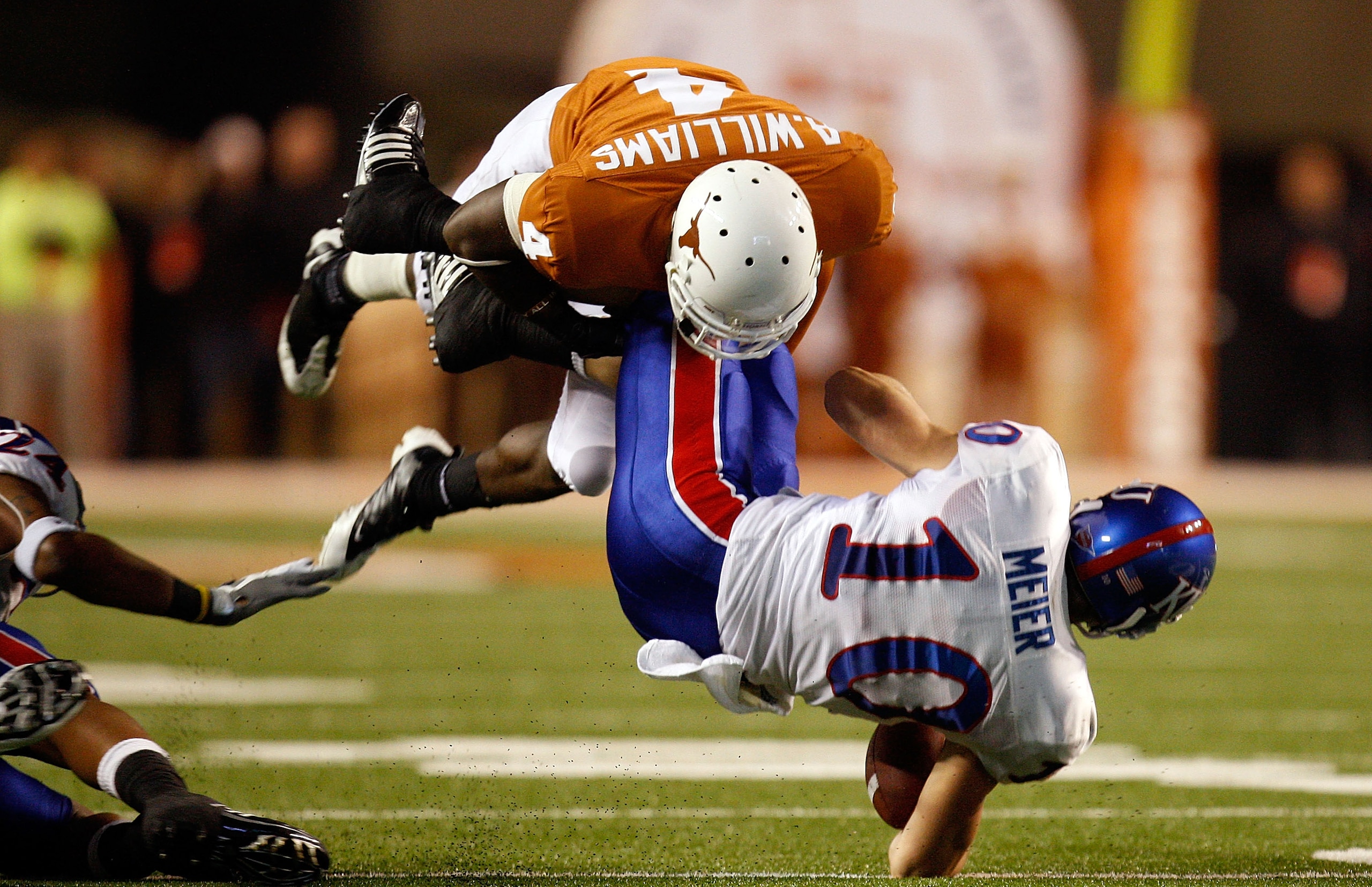 AUSTIN, TX - NOVEMBER 21:  Wide receiver Kerry Meier #10 of the Kansas Jayhawks is tackled by Aaron Williams #4 of the Texas Longhorns at Darrell K Royal-Texas Memorial Stadium on November 21, 2009 in Austin, Texas.  (Photo by Ronald Martinez/Getty Images