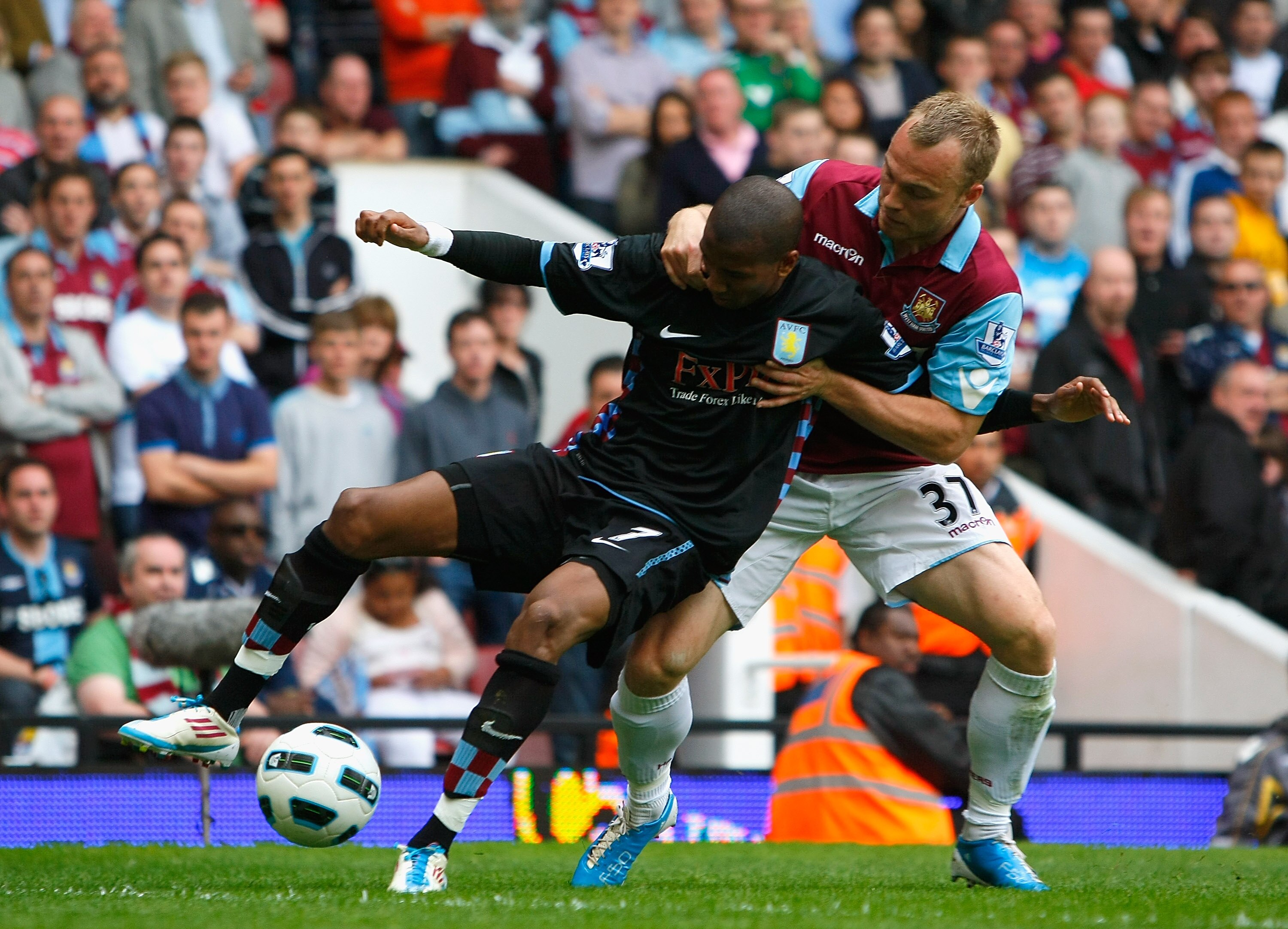 LONDON, ENGLAND - APRIL 16:  Ashley Young of Aston Villa holds off the challenge by Lars Jacobsen of West Ham United during the Barclays Premier League match between West Ham United and Aston Villa at the Boleyn Ground on April 16, 2011 in London, England