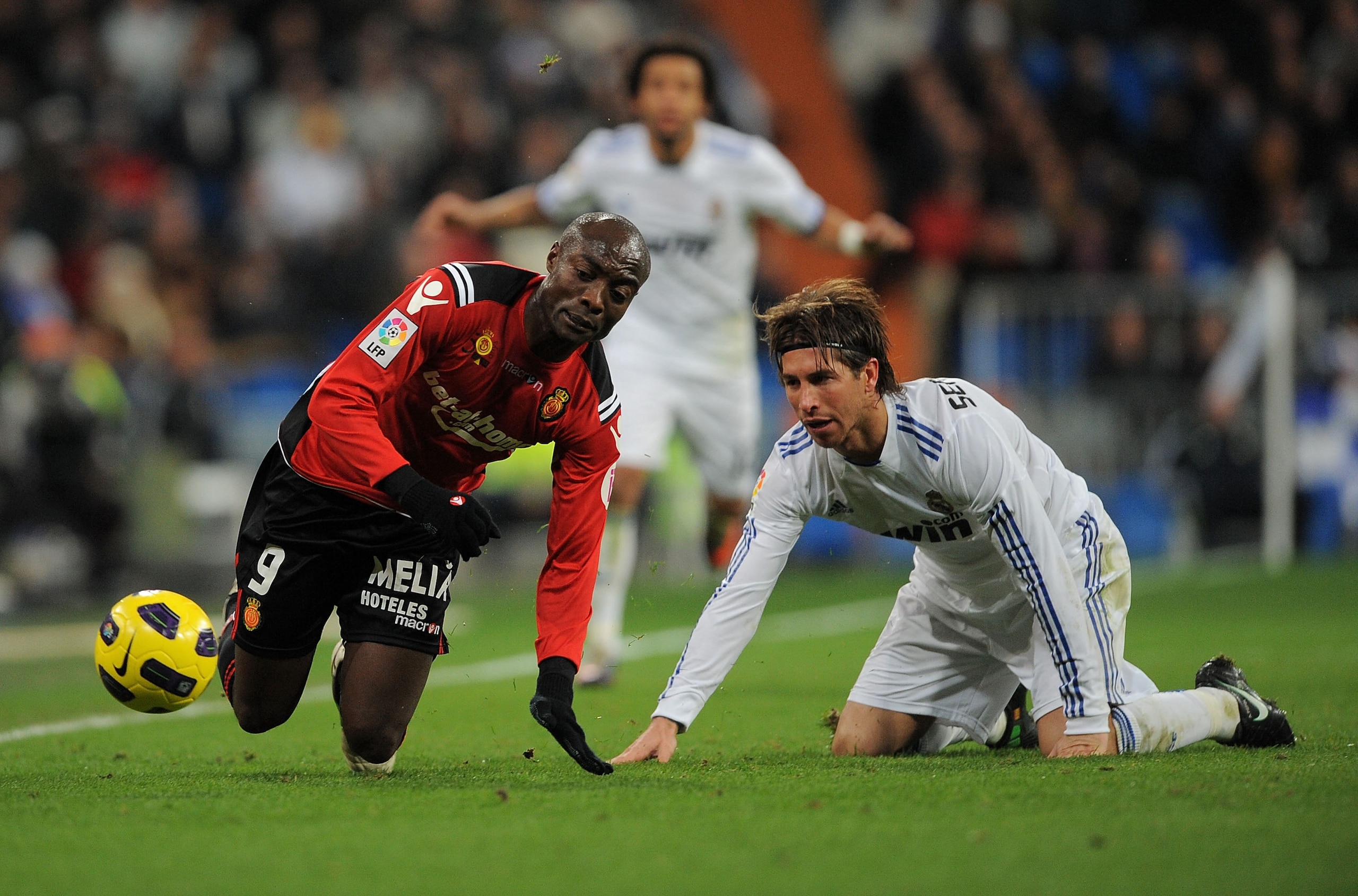 MADRID, SPAIN - JANUARY 23: Pierre Webo (L) of Mallorca is tackloed by Sergio Ramos of Real Madrid during the La Liga match between Real Madrid and Mallorca at Estadio Santiago Bernabeu on January 23, 2011 in Madrid, Spain.  (Photo by Denis Doyle/Getty Im
