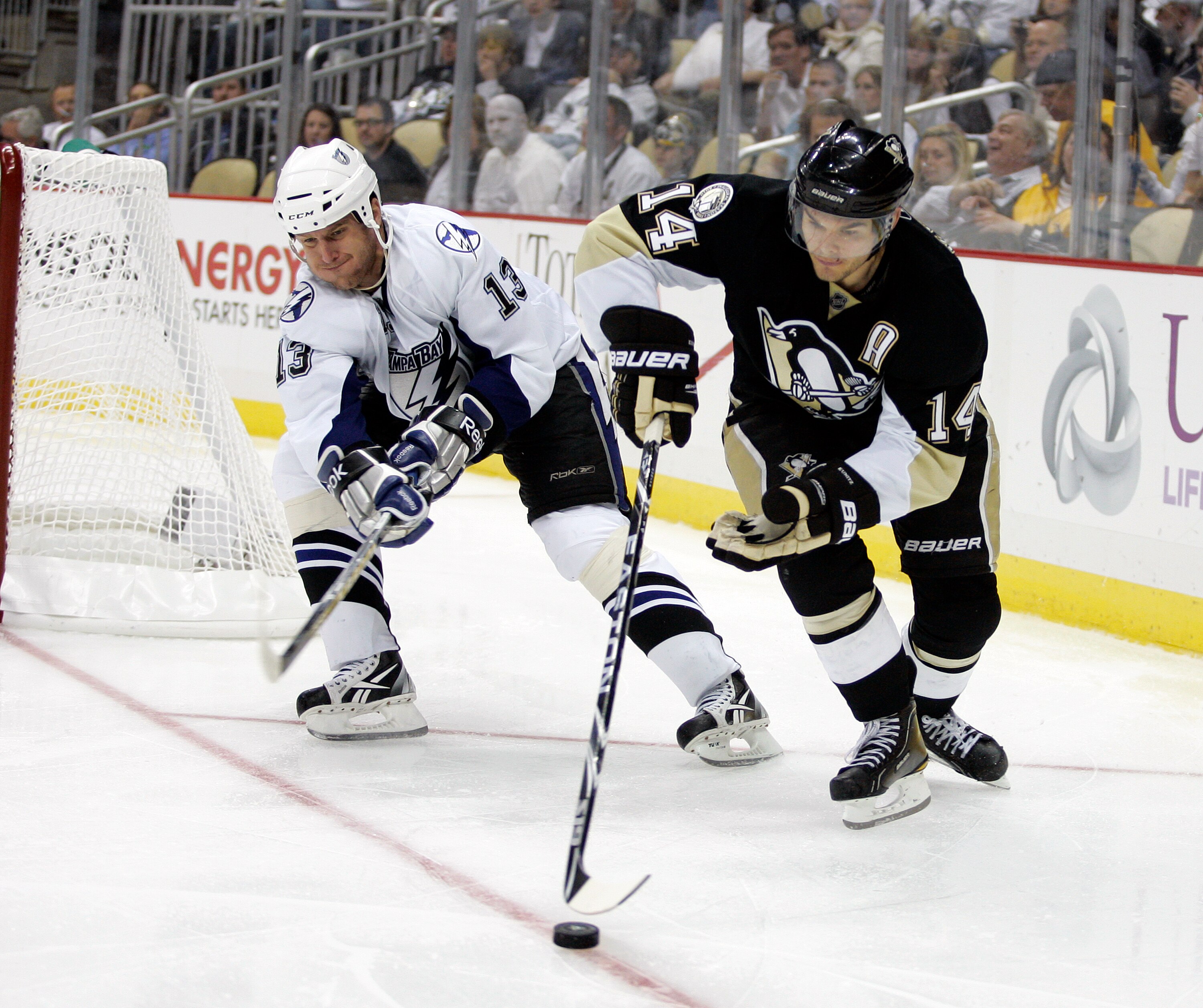 PITTSBURGH, PA - APRIL 23:  Chris Kunitz #14 of the Pittsburgh Penguins handles the puck in front of Pavel Kubina #13 of the Tampa Bay Lightning in Game Five of the Eastern Conference Quarterfinals during the 2011 NHL Stanley Cup Playoffs at Consol Energy