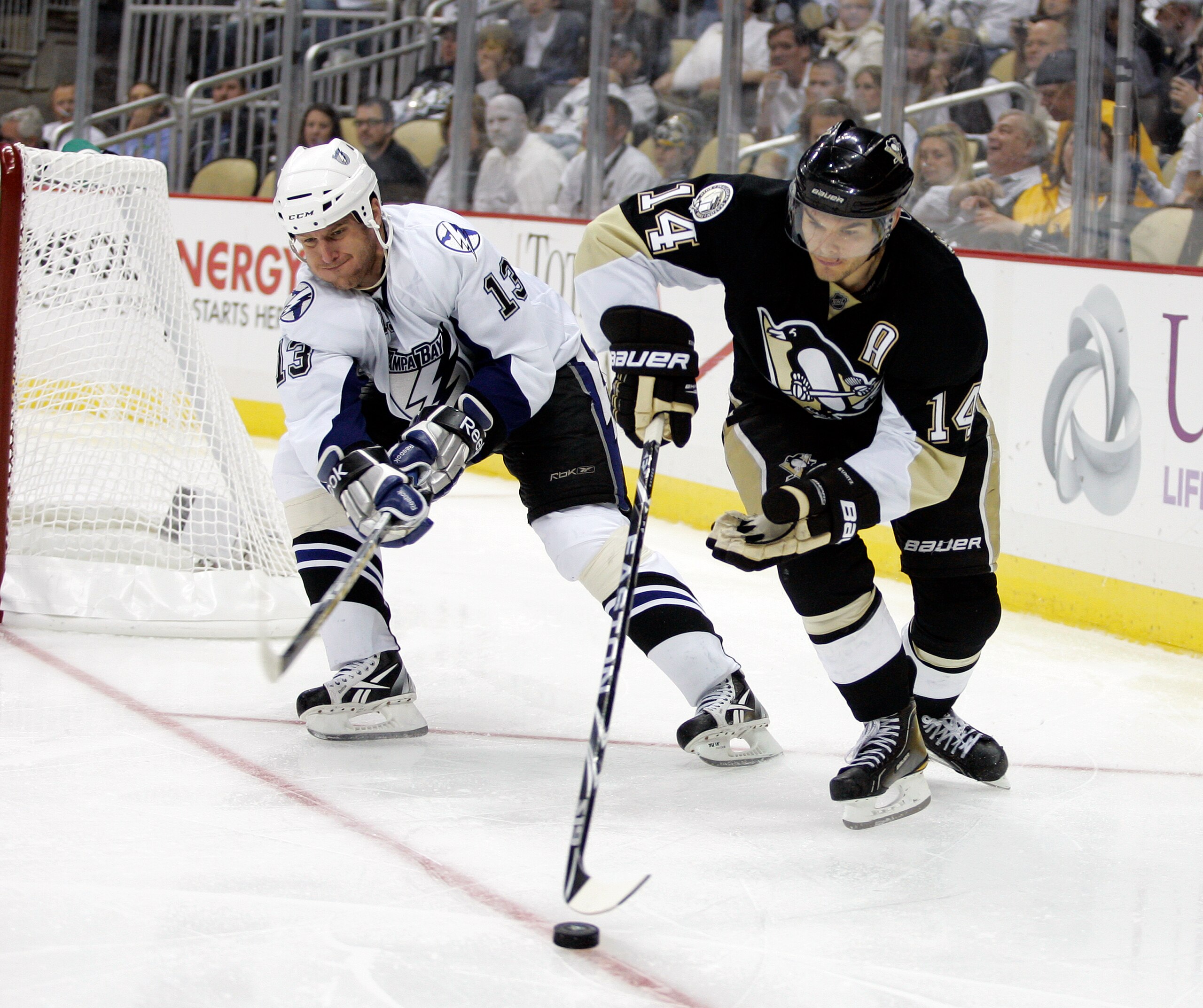 PITTSBURGH, PA - APRIL 23:  Chris Kunitz #14 of the Pittsburgh Penguins handles the puck in front of Pavel Kubina #13 of the Tampa Bay Lightning in Game Five of the Eastern Conference Quarterfinals during the 2011 NHL Stanley Cup Playoffs at Consol Energy