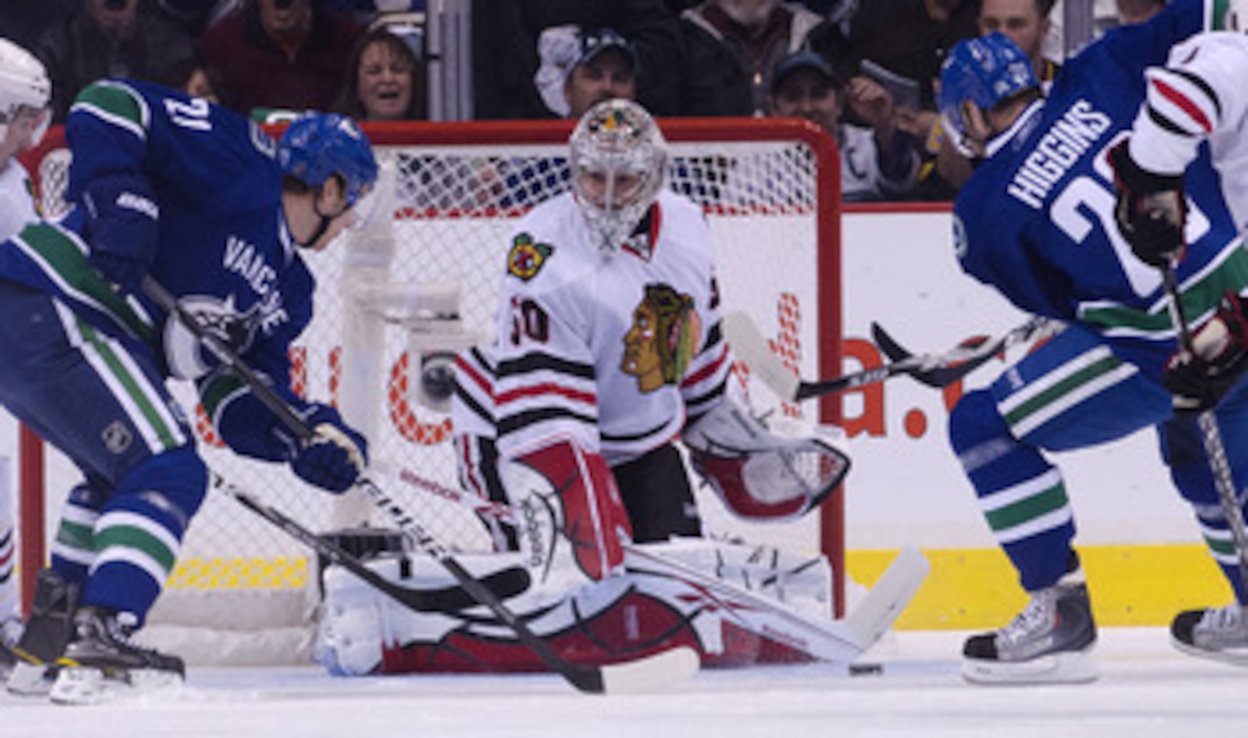 VANCOUVER, CANADA - APRIL 21: Mason Raymond #21 and Chris Higgins #20 of the Vancouver Canucks lok on as goalie Corey Crawford #50 of the Chicago Blackhawks makes a save during the first period in Game Five of the Western Conference Quarterfinals during t