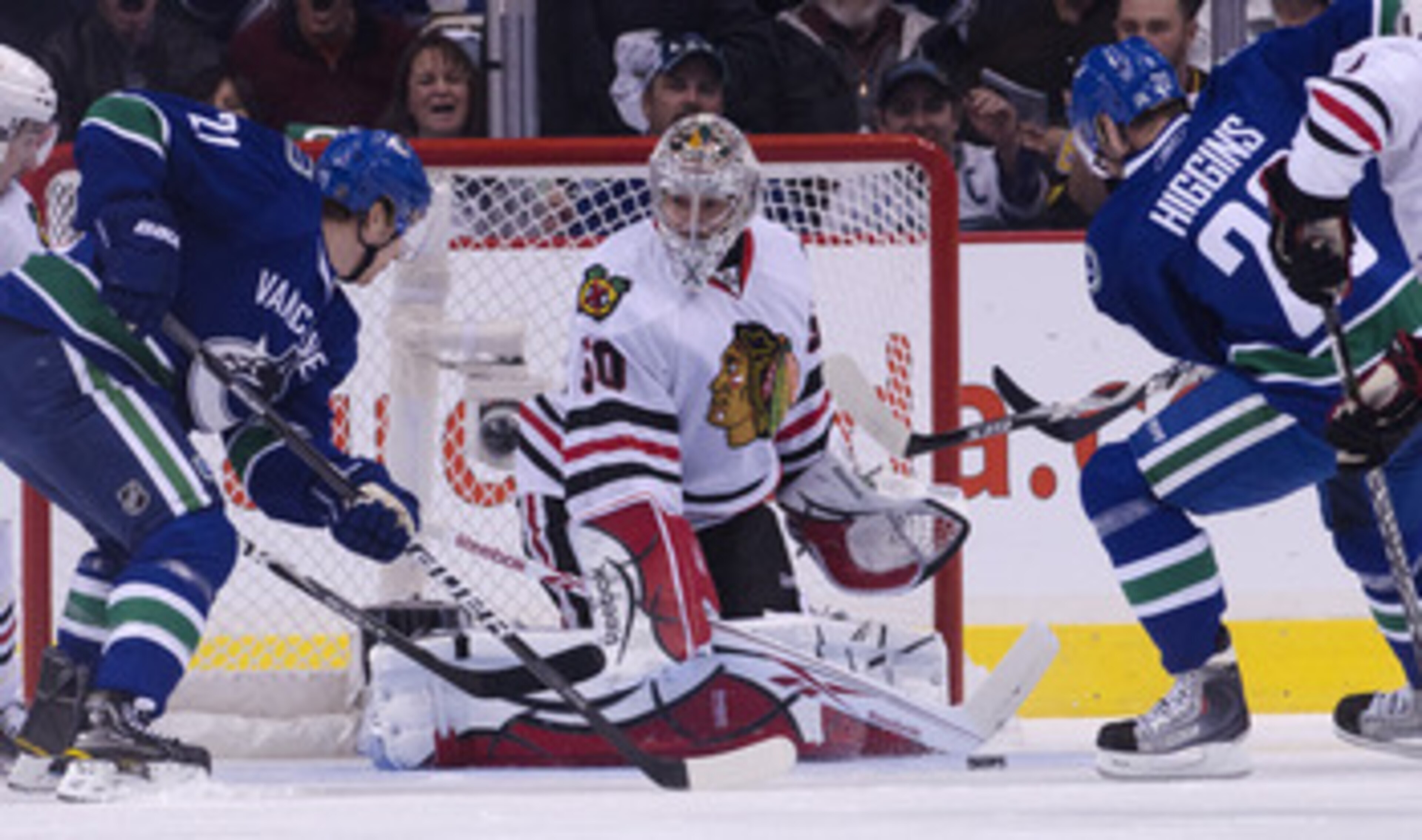 VANCOUVER, CANADA - APRIL 21: Mason Raymond #21 and Chris Higgins #20 of the Vancouver Canucks lok on as goalie Corey Crawford #50 of the Chicago Blackhawks makes a save during the first period in Game Five of the Western Conference Quarterfinals during t