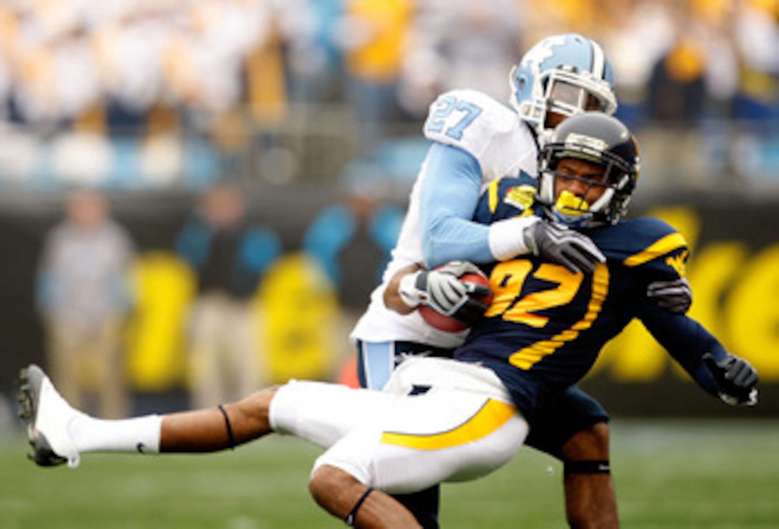 CHARLOTTE, NC - DECEMBER 27:  Deunta Williams #27 of the North Carolina Tar Heels tackles Alric Arnett #82 of the West Virginia Mountaineers during the Meineke Car Care Bowl on December 27, 2008 at Bank of America Stadium in Charlotte, North Carolina.  (P