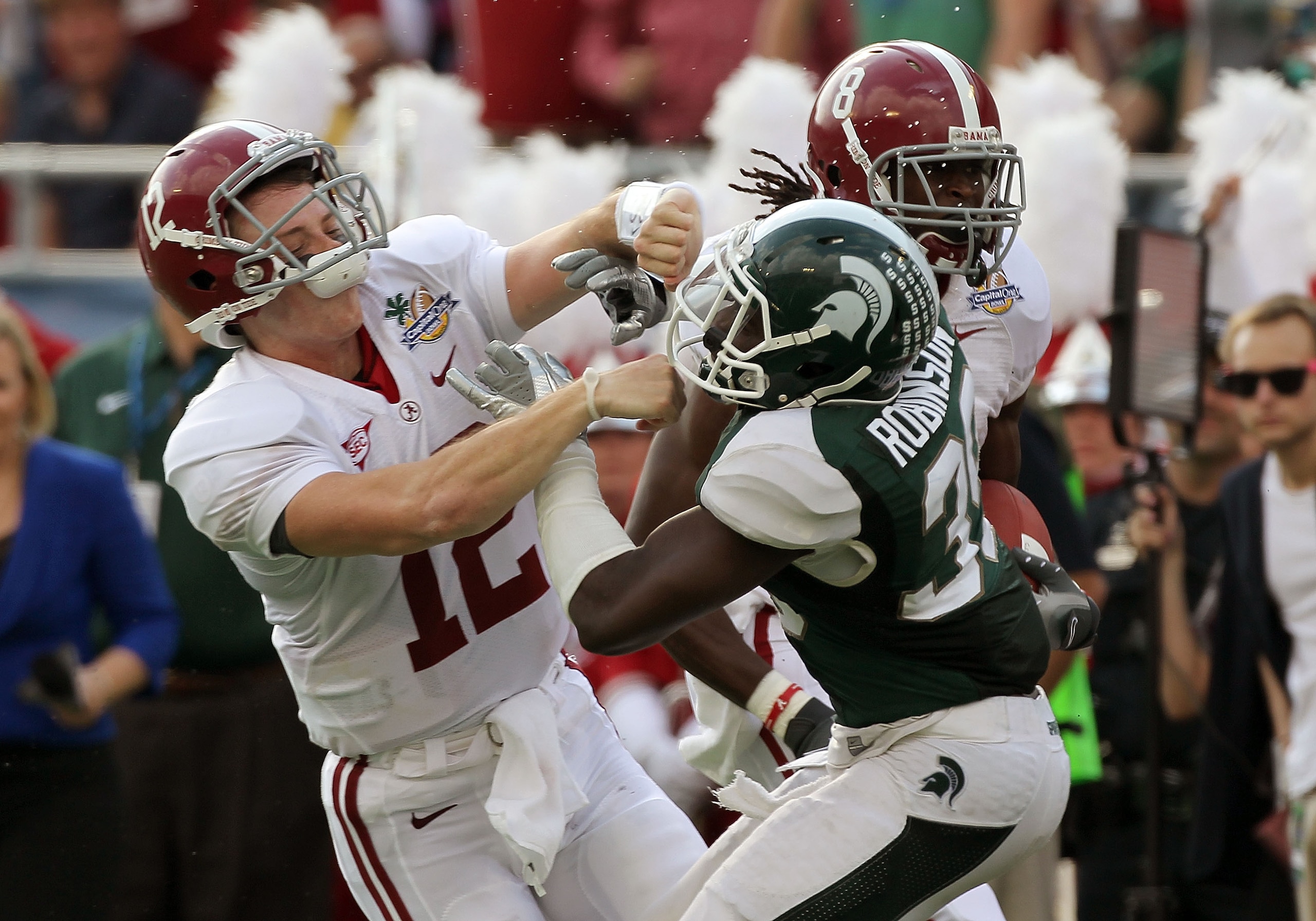 ORLANDO, FL - JANUARY 01:  Greg McElroy #12 of the Alabama Crimson Tide blocks Trenton Robinson #39 of  the Michigan State Spartans on a touchdown run during the Capitol One Bowl at the Florida Citrus Bowl on January 1, 2011 in Orlando, Florida.  (Photo b