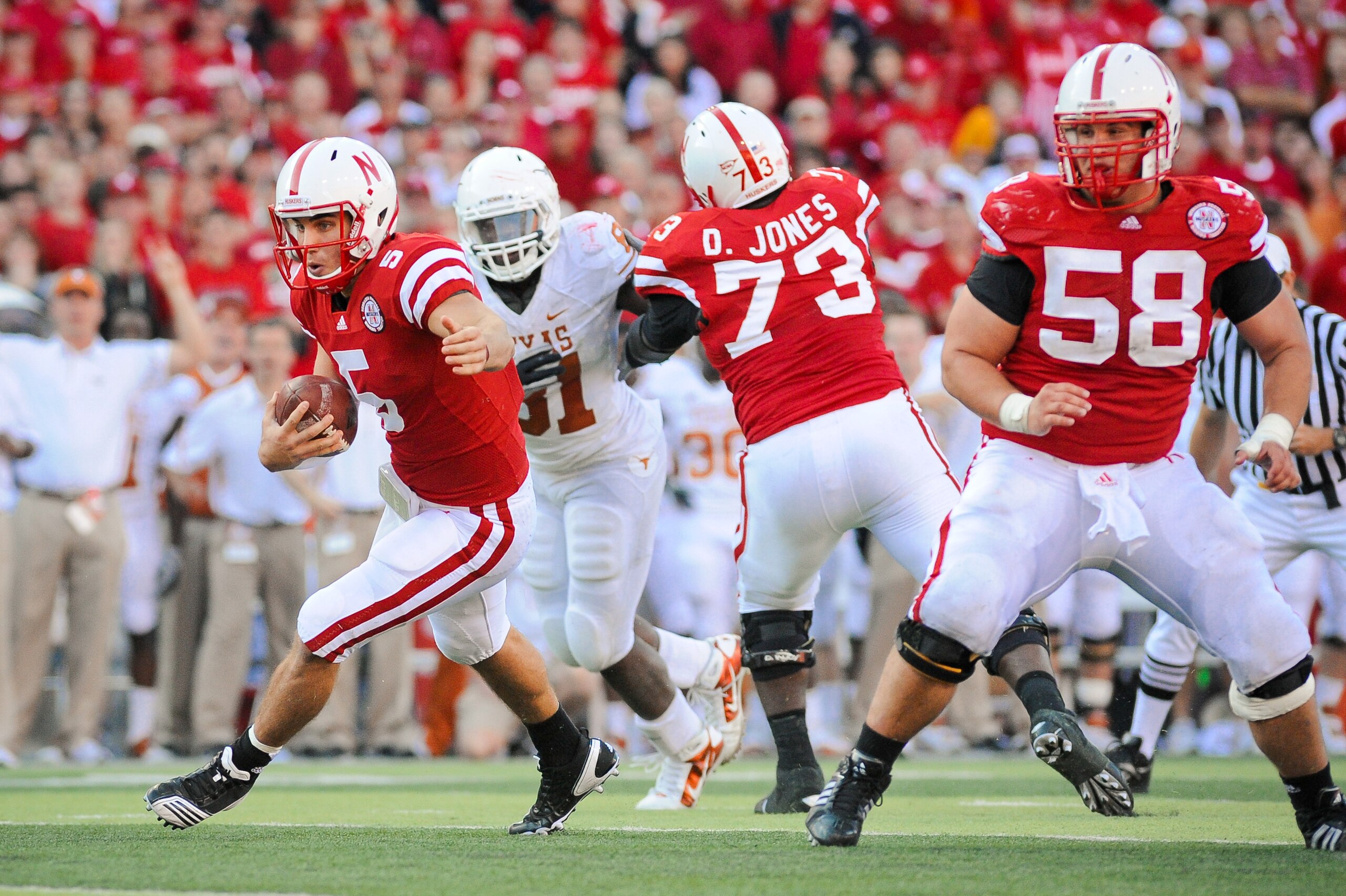 LINCOLN, NE - OCTOBER 16: Quarterback Zac Lee #5 of the Nebraska Cornhuskers runs through a hole created by offensive linesman Mike Caputo #58 and D.J. Jones #73 of the Nebraska Cornhuskers during their game at Memorial Stadium on October 16, 2010 in Linc LINCOLN, NE - OCTOBER 16: Quarterback Zac Lee #5 of the Nebraska Cornhuskers runs through a hole created by offensive linesman Mike Caputo #58 and D.J. Jones #73 of the Nebraska Cornhuskers during their game at Memorial Stadium on October 16, 2010 in Linc