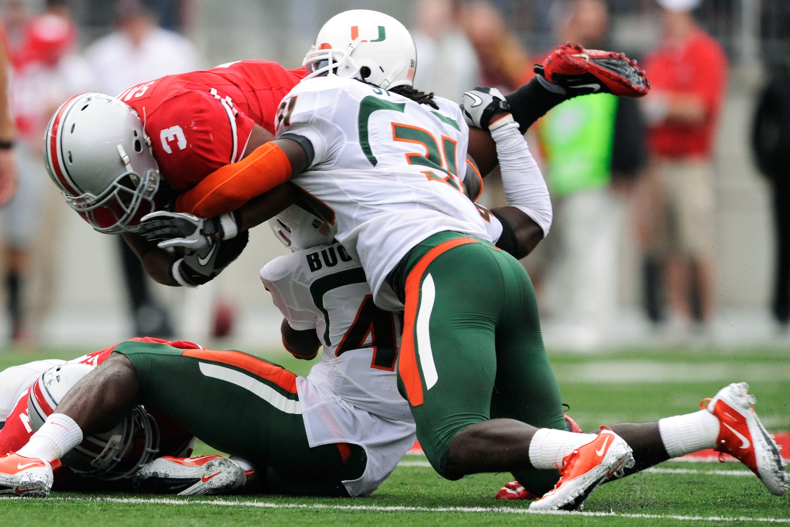 COLUMBUS, OH - SEPTEMBER 11: Ramon Buchanan #45 of the Miami Hurricanes and Sean Spence #31 of the Hurricanes bring down Brandon Saine #3 of the Ohio State Buckeyes at Ohio Stadium on September 11, 2010 in Columbus, Ohio. (Photo by Jamie Sabau/Getty Ima COLUMBUS, OH - SEPTEMBER 11: Ramon Buchanan #45 of the Miami Hurricanes and Sean Spence #31 of the Hurricanes bring down Brandon Saine #3 of the Ohio State Buckeyes at Ohio Stadium on September 11, 2010 in Columbus, Ohio. (Photo by Jamie Sabau/Getty Ima