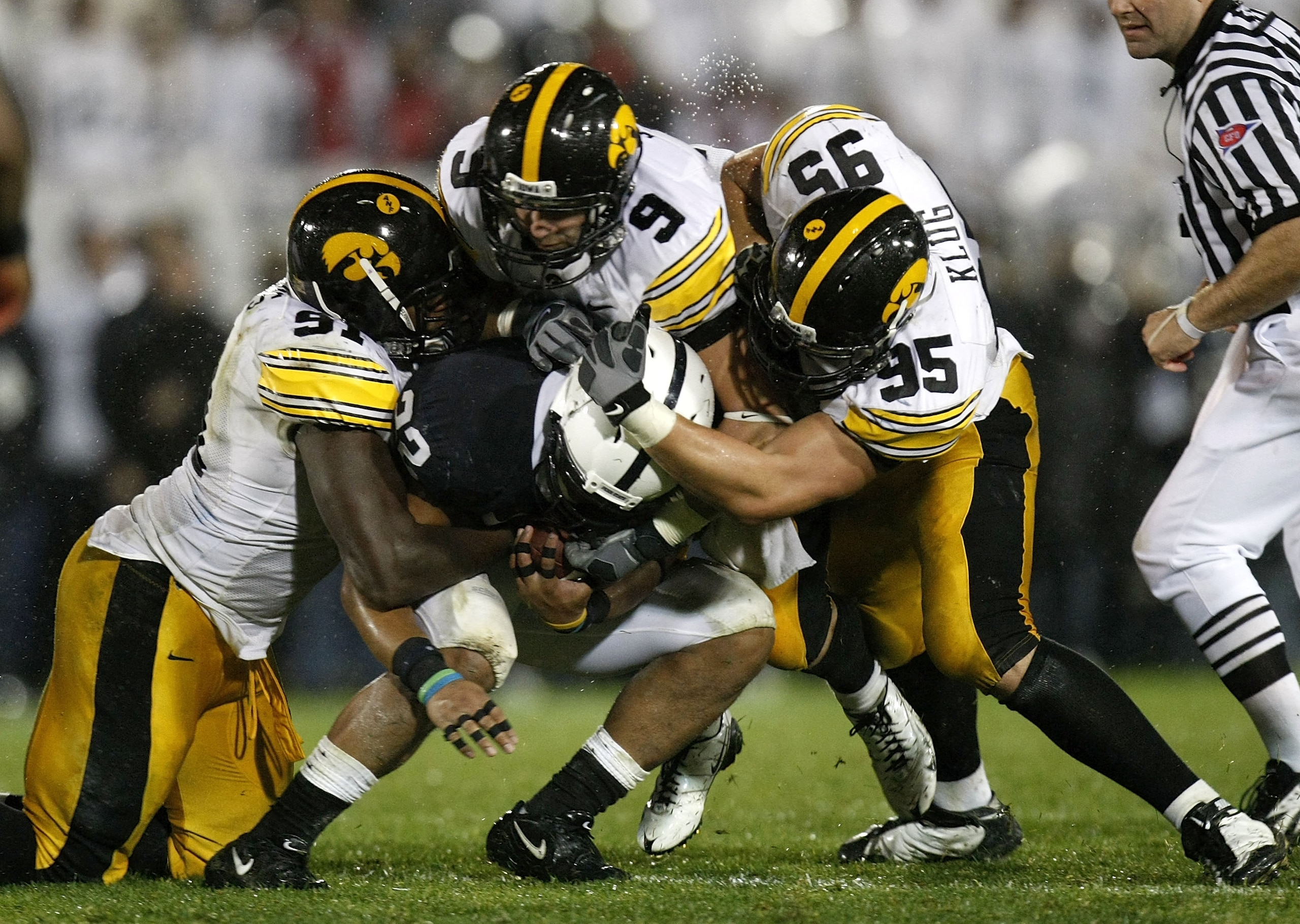 STATE COLLEGE, PA - SEPTEMBER 26:  Evan Royster #22 of the Penn State Nittnay Lions is tackled by Karl Klug #95, Tyler Sash #9, and Broderick Binns #91 of the Iowa Hawkeye's on September 26, 2009 at Beaver Stadium in State College, Pennsylvania. Iowa won