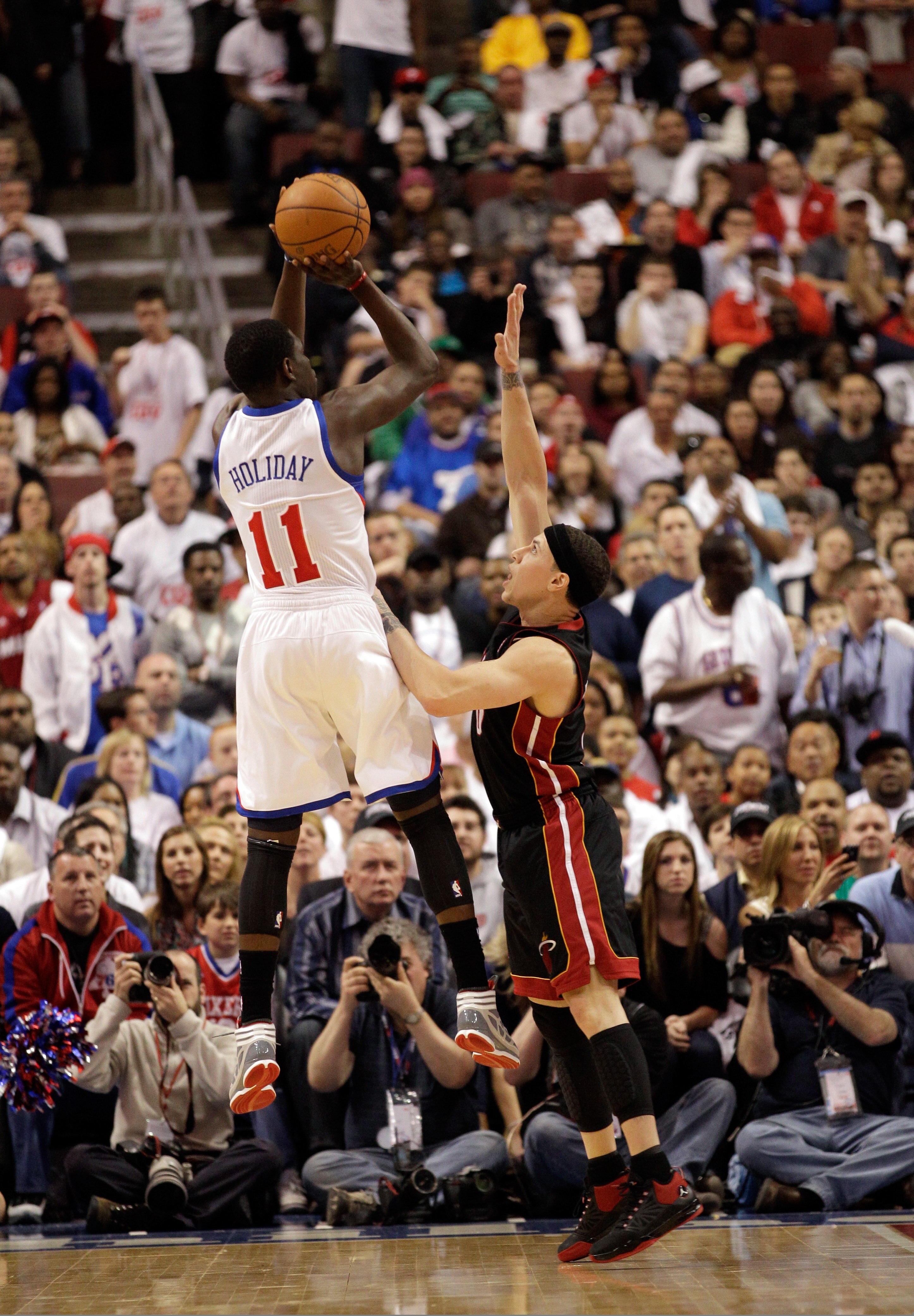 PHILADELPHIA, PA - APRIL 21: Jrue Holiday #11 of the Philadelphia 76ers shoots over Mike Bibby #0 of the Miami Heat in Game Three of the Eastern Conference Quarterfinals during the 2011 NBA Playoffs at Wells Fargo Center on April 21, 2011 in Philadelphia,