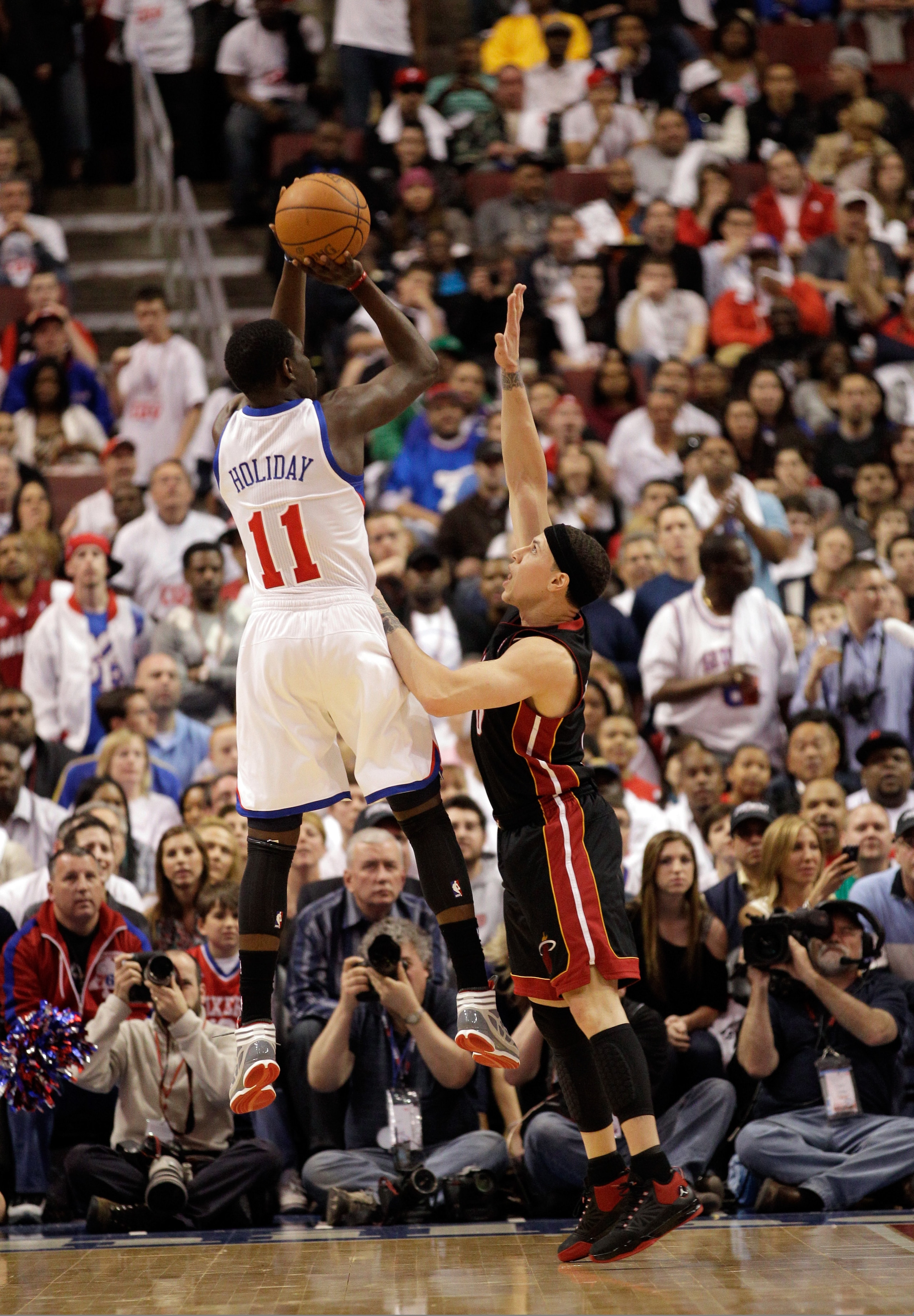 PHILADELPHIA, PA - APRIL 21: Jrue Holiday #11 of the Philadelphia 76ers shoots over Mike Bibby #0 of the Miami Heat in Game Three of the Eastern Conference Quarterfinals during the 2011 NBA Playoffs at Wells Fargo Center on April 21, 2011 in Philadelphia,