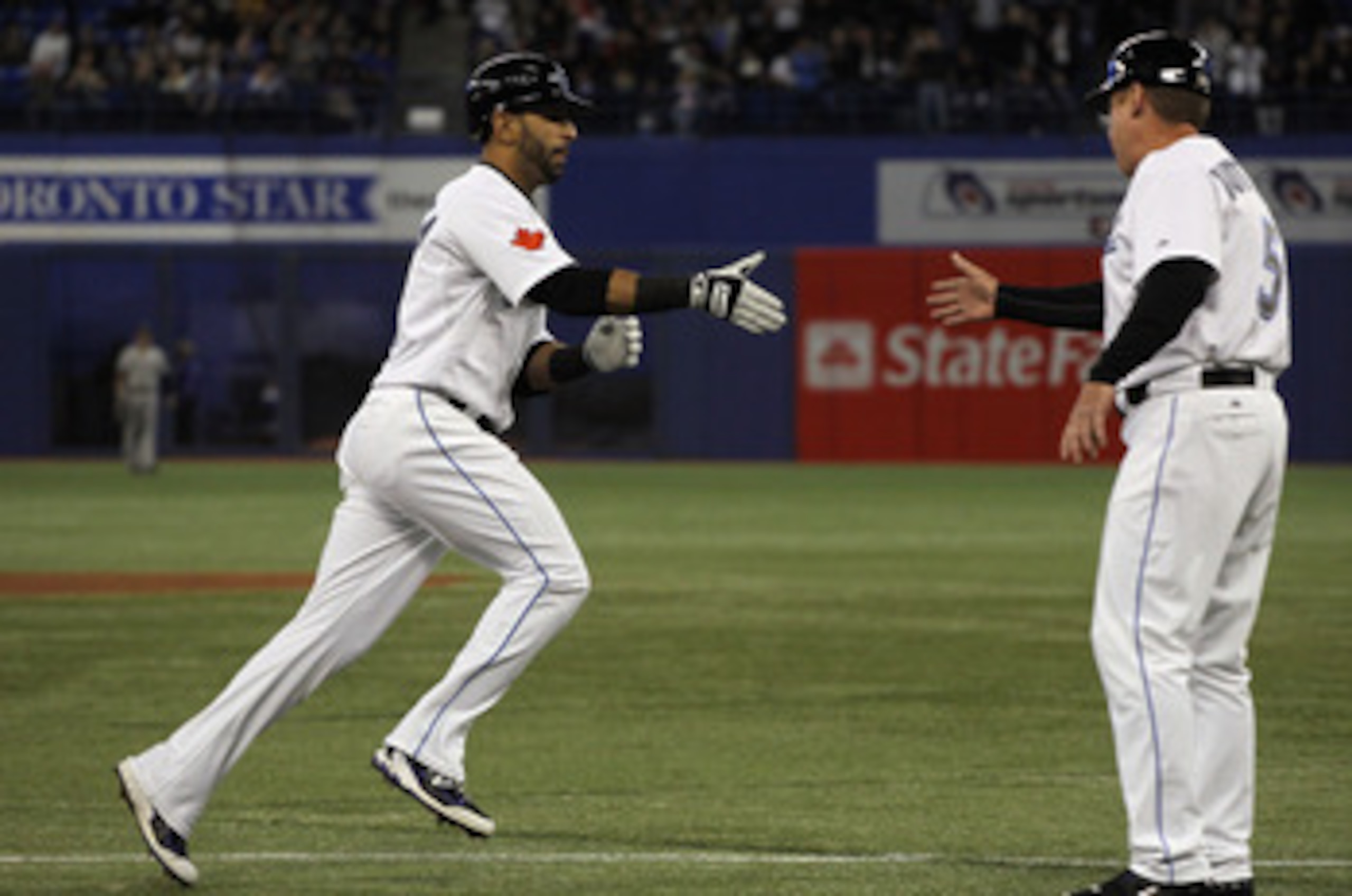 TORONTO, ON - APRIL 19:  Jose Bautista #19 (L) of the Toronto Blue Jays celebrates with coach Brian Butterfield #55 after Bautista's first inning home run during their game against the New York Yankees at Rogers Centre on April 19, 2011 in Toronto, Canada