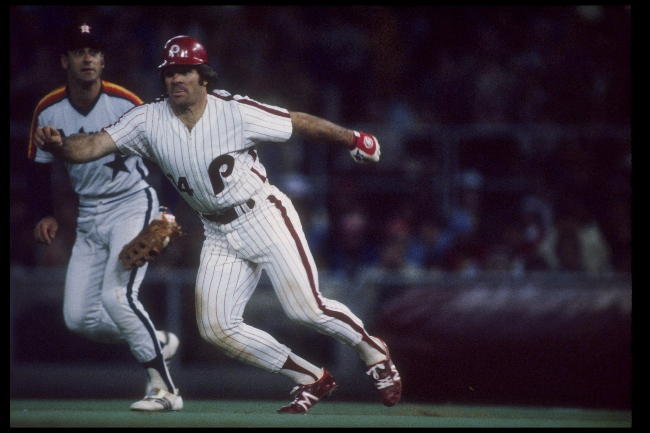 Infielder Pete Rose of the Philadelphia Phillies runs off the base as infielder Art Howe of the Houston Astros watches during a game at Veterans Stadium in Philadephia, Pennsylvania.