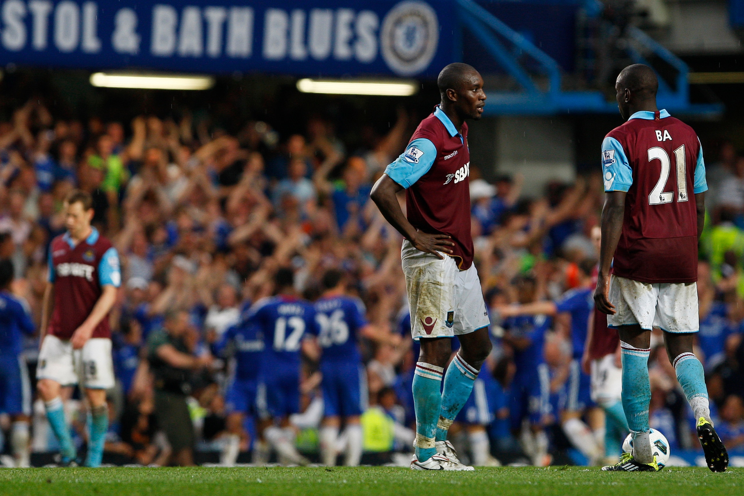 LONDON, ENGLAND - APRIL 23:  Demba Ba (R) and Carlton Cole of West Ham show their dejection as Chelsea players celebrate team mate Frank Lampard's opening goal during the Barclays Premier League match between Chelsea and West Ham United at Stamford Bridge