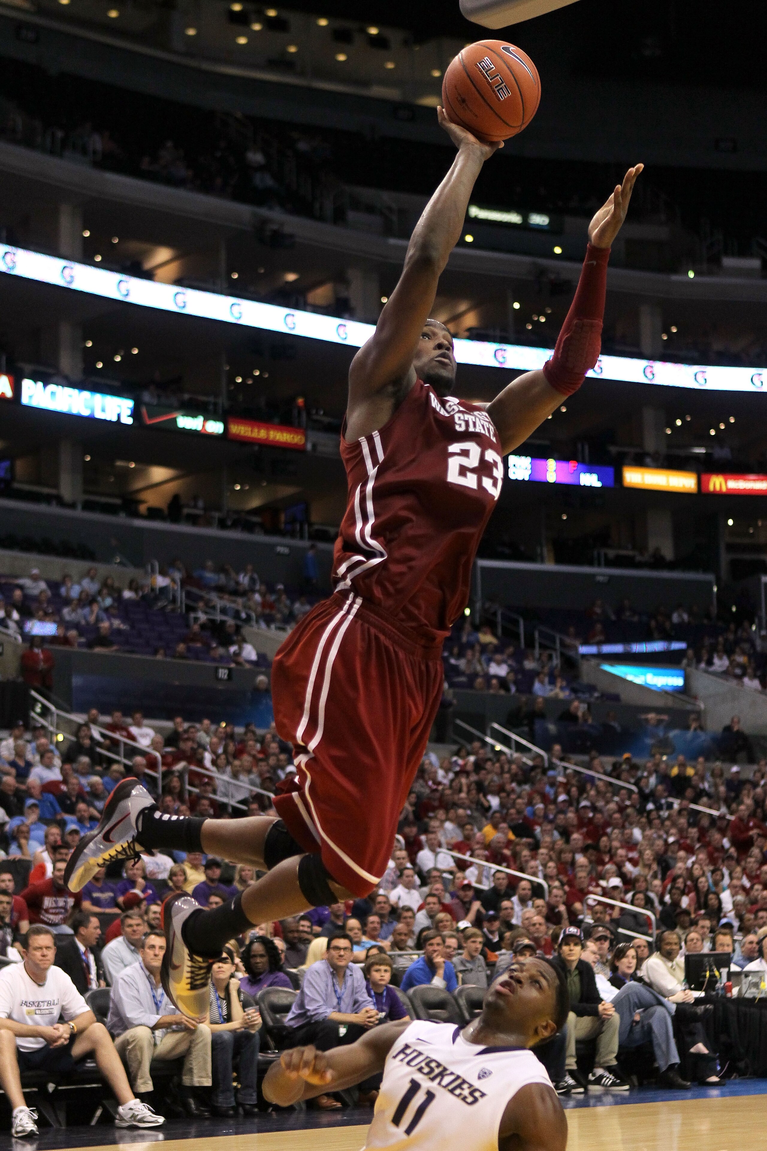 LOS ANGELES, CA - MARCH 10:  DeAngelo Casto #23 of the Washington State Cougars shoots over Matthew Bryan-Amaning #11 of the Washington Huskies in the second half in the quarterfinals of the 2011 Pacific Life Pac-10 Men's Basketball Tournament at Staples