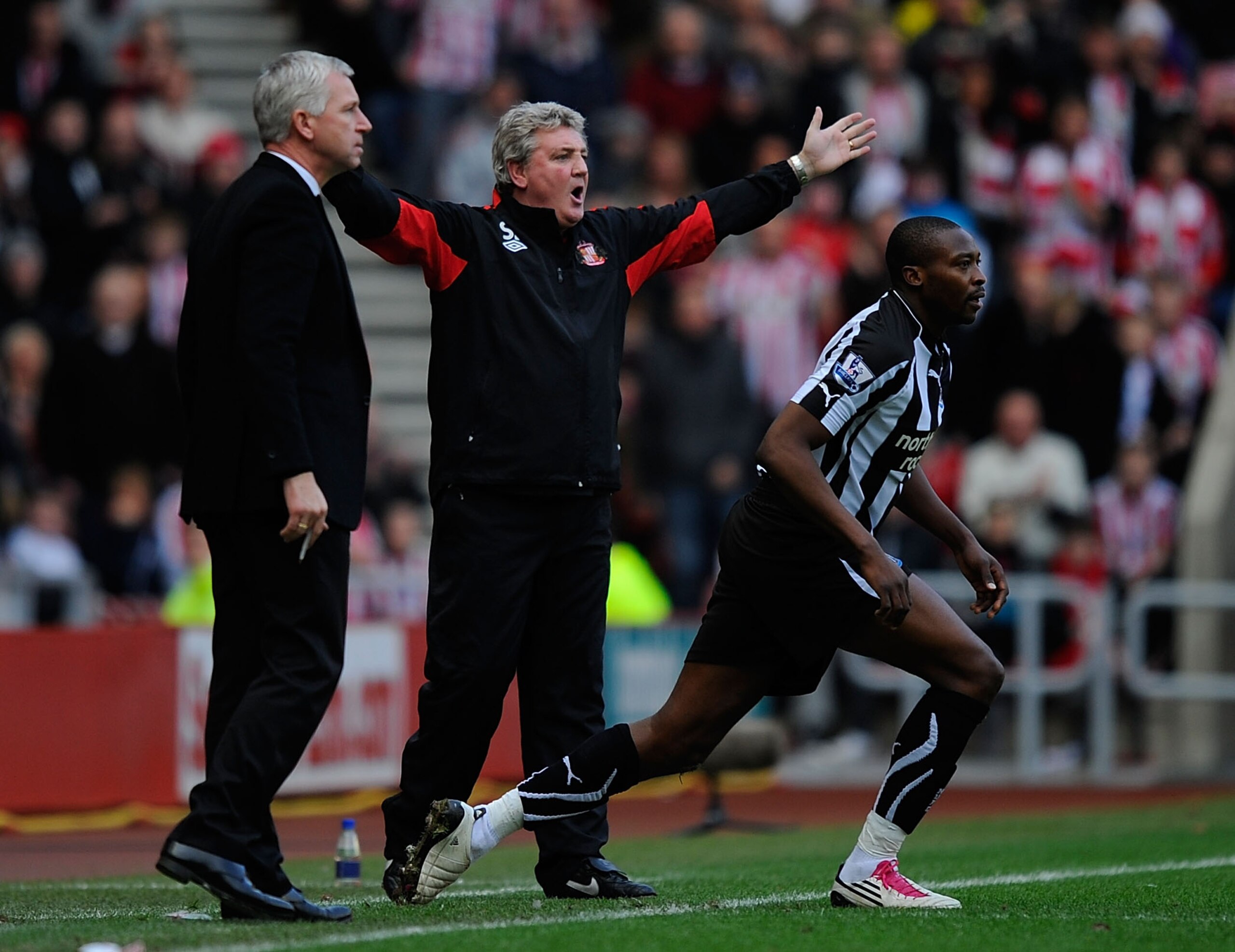 SUNDERLAND, ENGLAND - JANUARY 16:  Newcastle manager Alan Pardew (L) and Steve Bruce (C) react to a challenge on Shola Ameobi during the Barclays Premier League match between Sunderland and Newcastle United at Stadium of Light on January 16, 2011 in Sunde