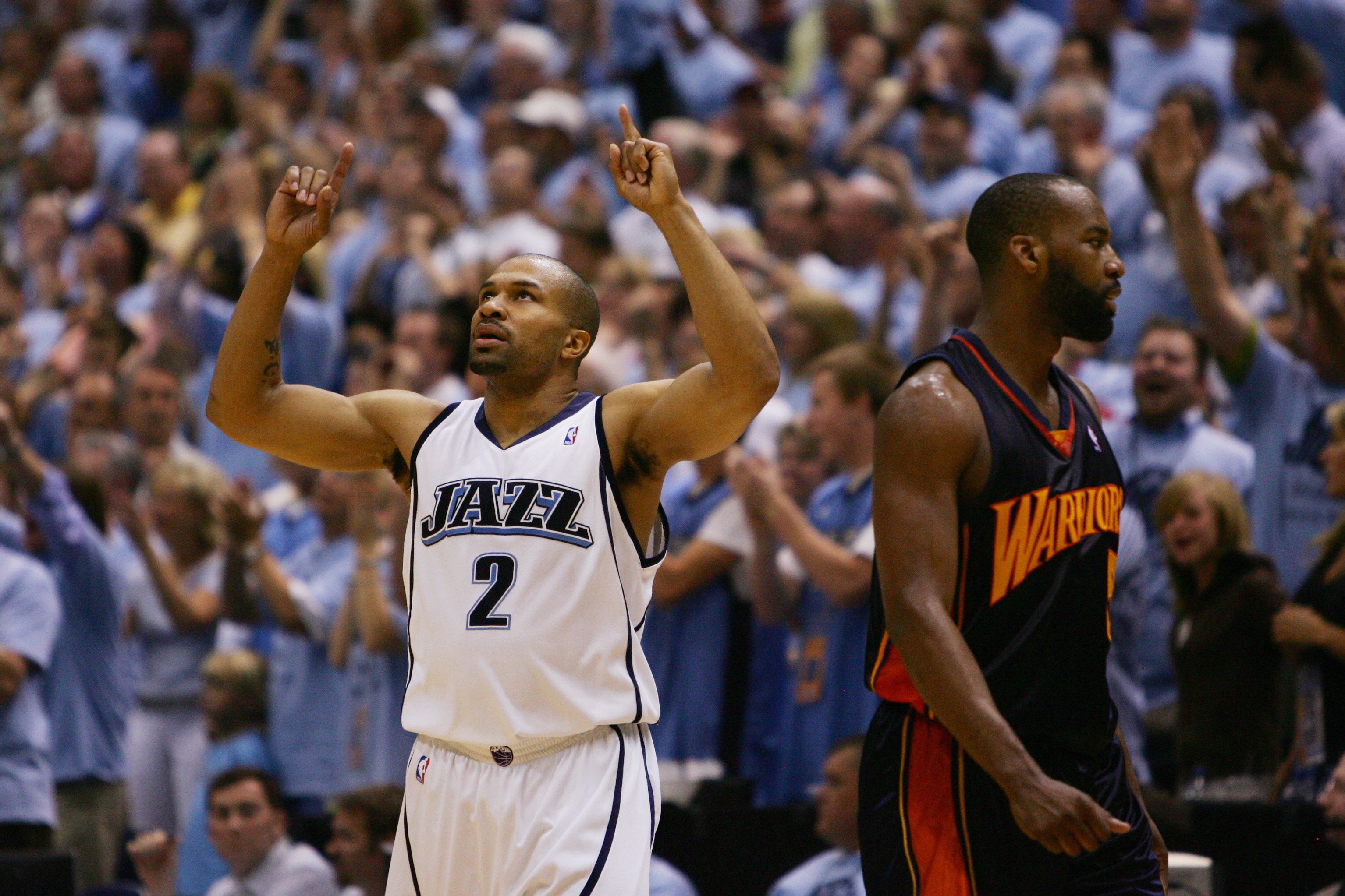 SALT LAKE CITY - MAY 9:  Baron Davis #5 of the Golden State Warriors walks to the sidelines as Derek Fisher #2 of the Utah Jazz celebrates in the closing minutes of overtime in Game Two of the Western Conference Semifinals during the 2007 NBA Playoffs at