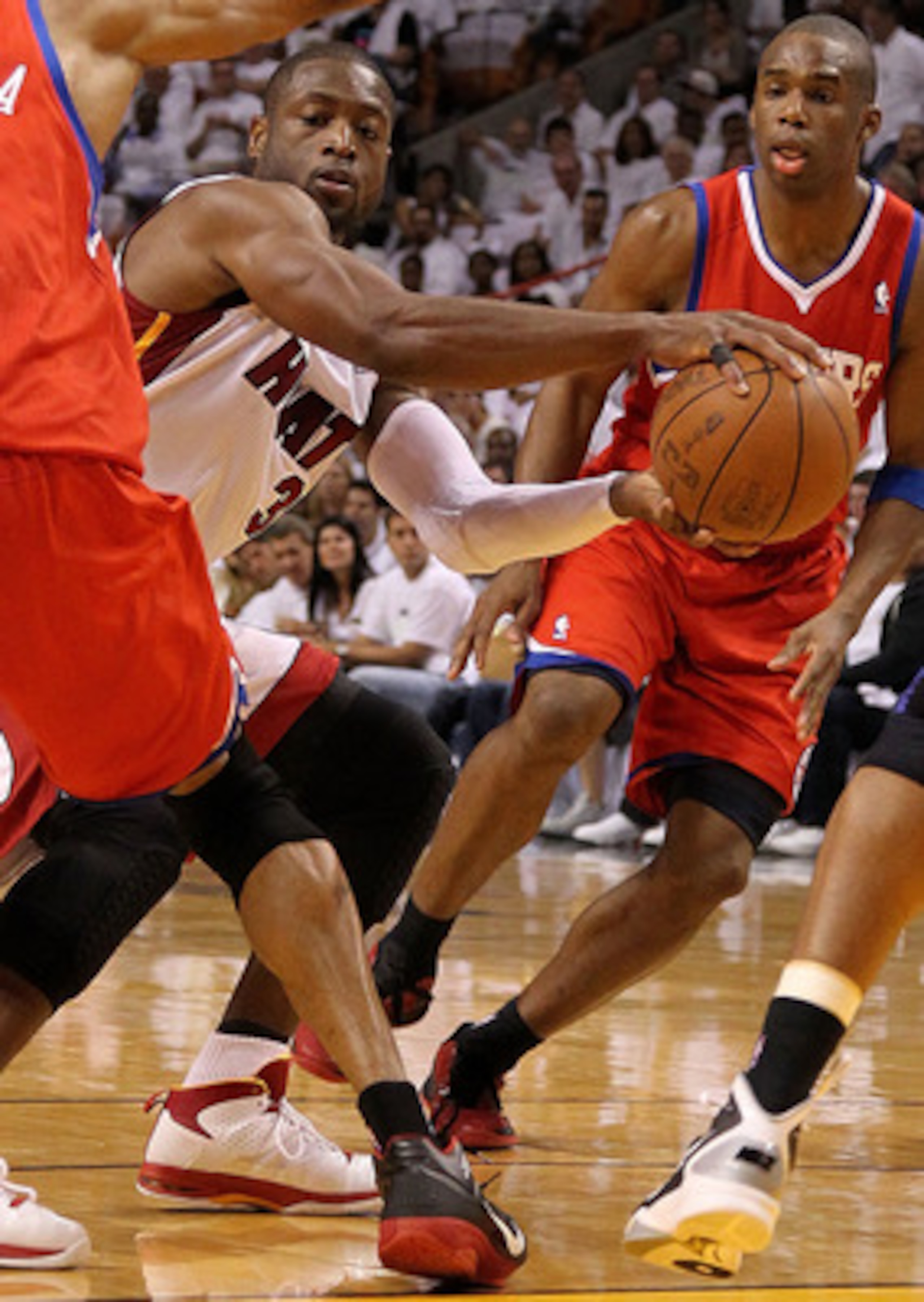 MIAMI, FL - APRIL 18:  Dwyane Wade #3 of the Miami Heat passes around Andre Iguodala #9 of the Philadelphia 76ers during game two of the Eastern Conference Quarterfinals at American Airlines Arena on April 18, 2011 in Miami, Florida. NOTE TO USER: User ex