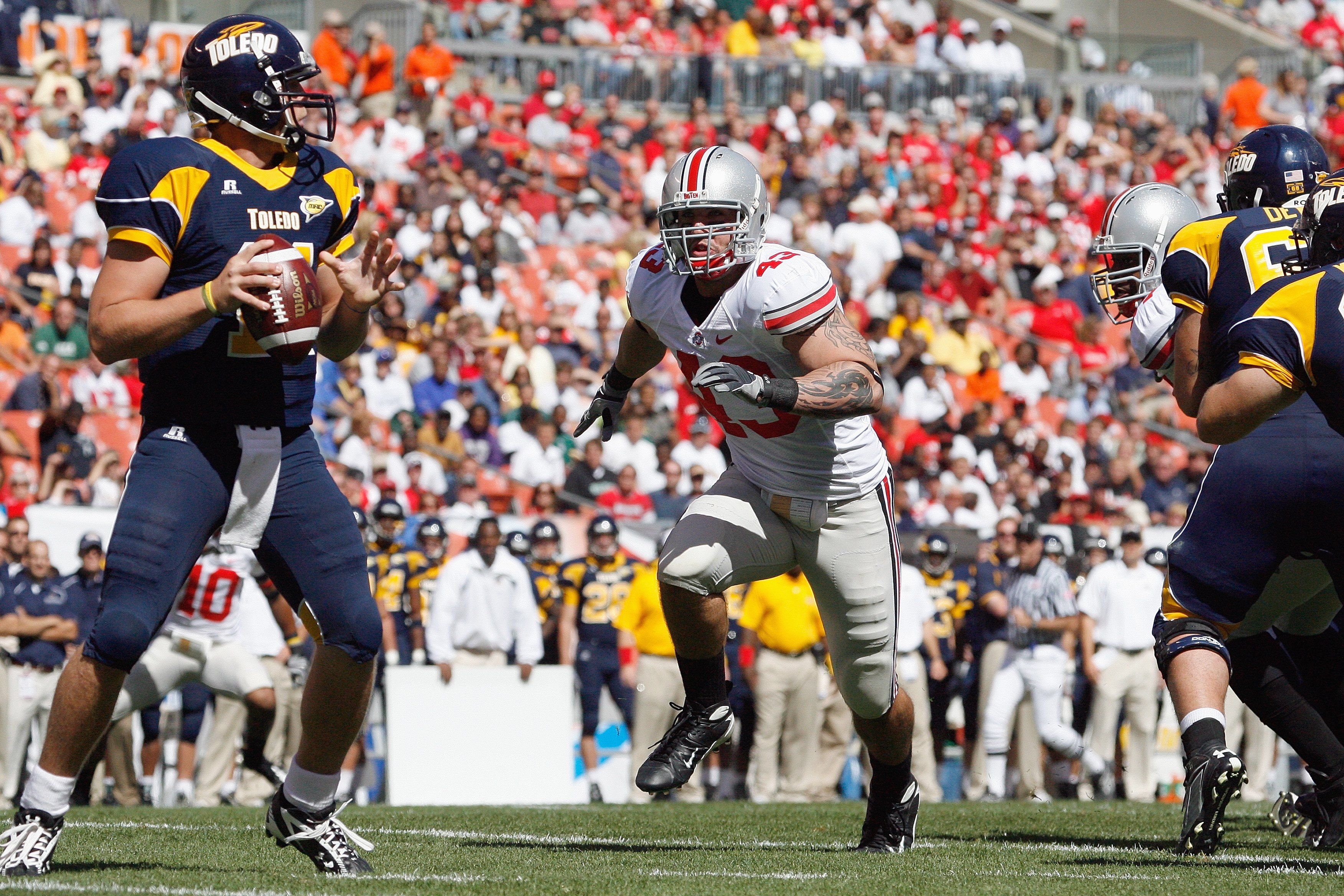 CLEVELAND - SEPTEMBER 19: Nathan Williams #43 of the Ohio State Buckeyes rushes quarterback Aaron Opelt #11 the Toledo Rockets at Cleveland Browns Stadium on September 19, 2009 in Cleveland, Ohio. The Ohio State Buckeyes shutout the Toledo Rockets 38-0. (