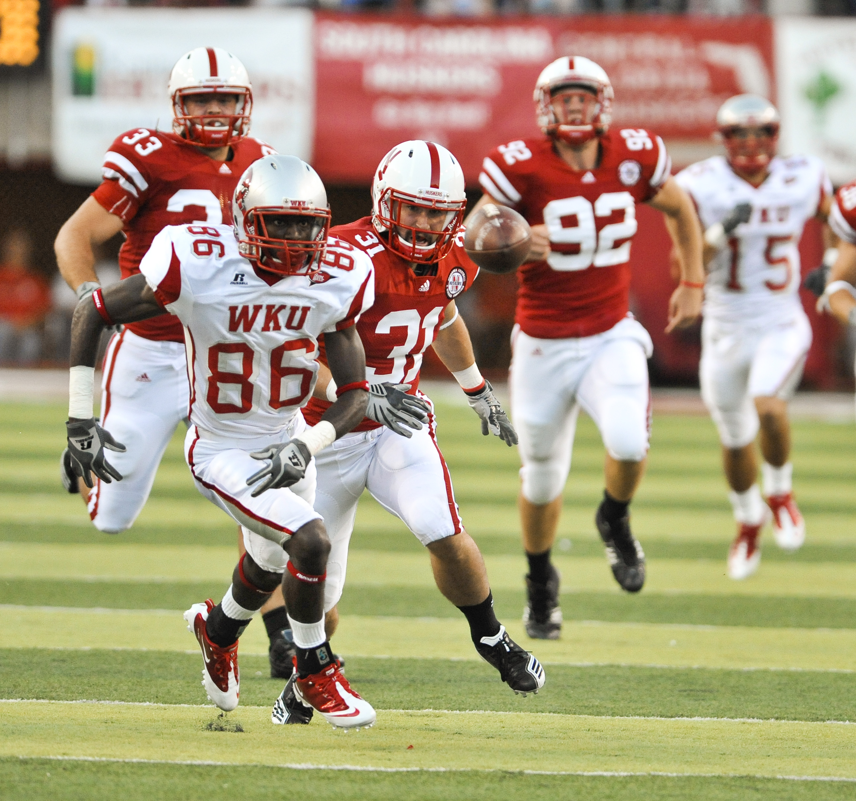 LINCOLN, NE - SEPTEMBER 04: Willie McNeal of the Western Kentucky Hilltoppers and Jase Dean #31 of the Nebraska Cornhuskers run after a mishandled punt during first half action of their game at Memorial Stadium on September 4, 2010 in Lincoln, Nebraska. N
