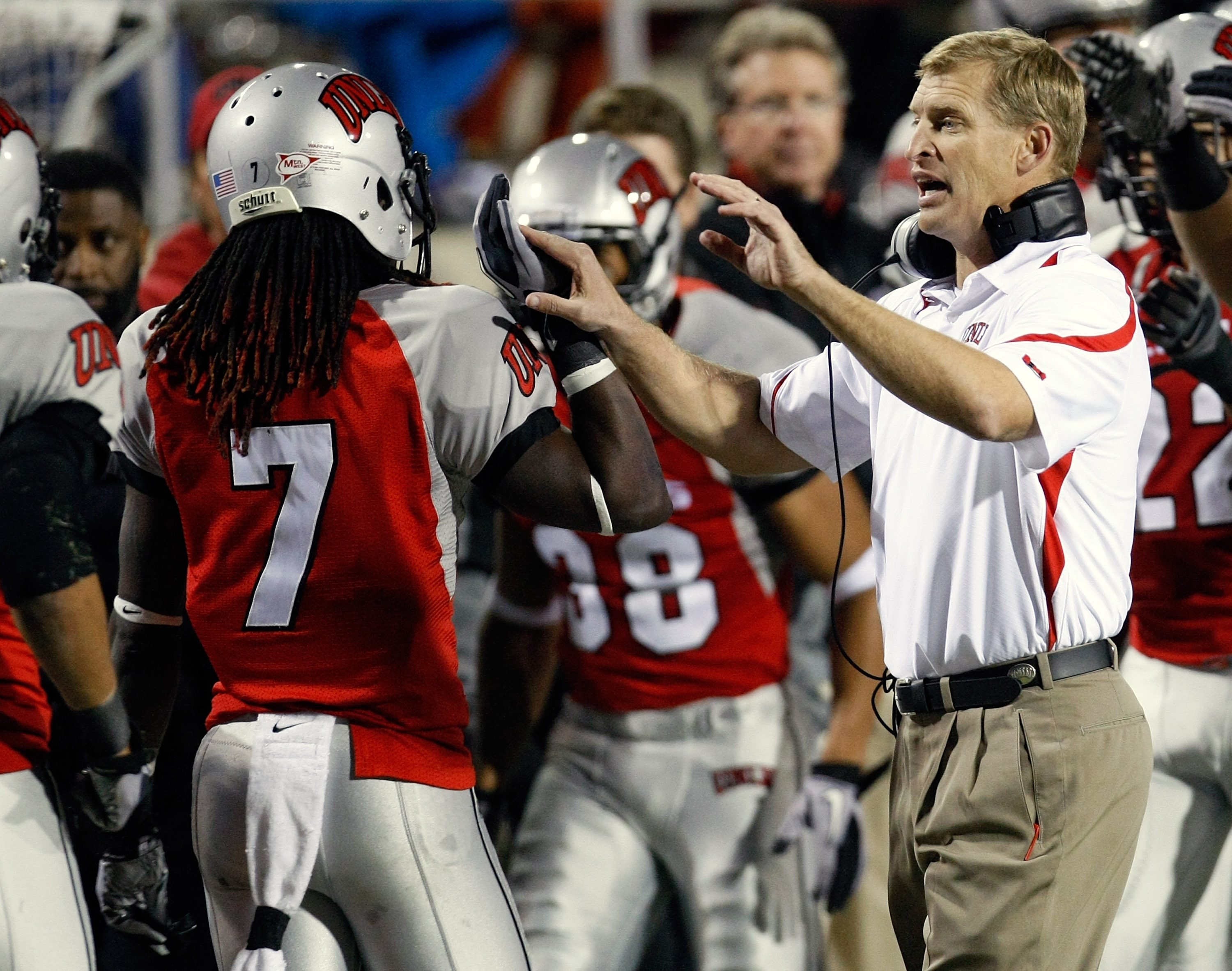 LAS VEGAS - NOVEMBER 13:  Head coach Bobby Hauck of the UNLV Rebels celebrates on the sideline with Michael Johnson #7 during a game against the Wyoming Cowboys at Sam Boyd Stadium November 13, 2010 in Las Vegas, Nevada. UNLV won 42-16.  (Photo by Ethan M