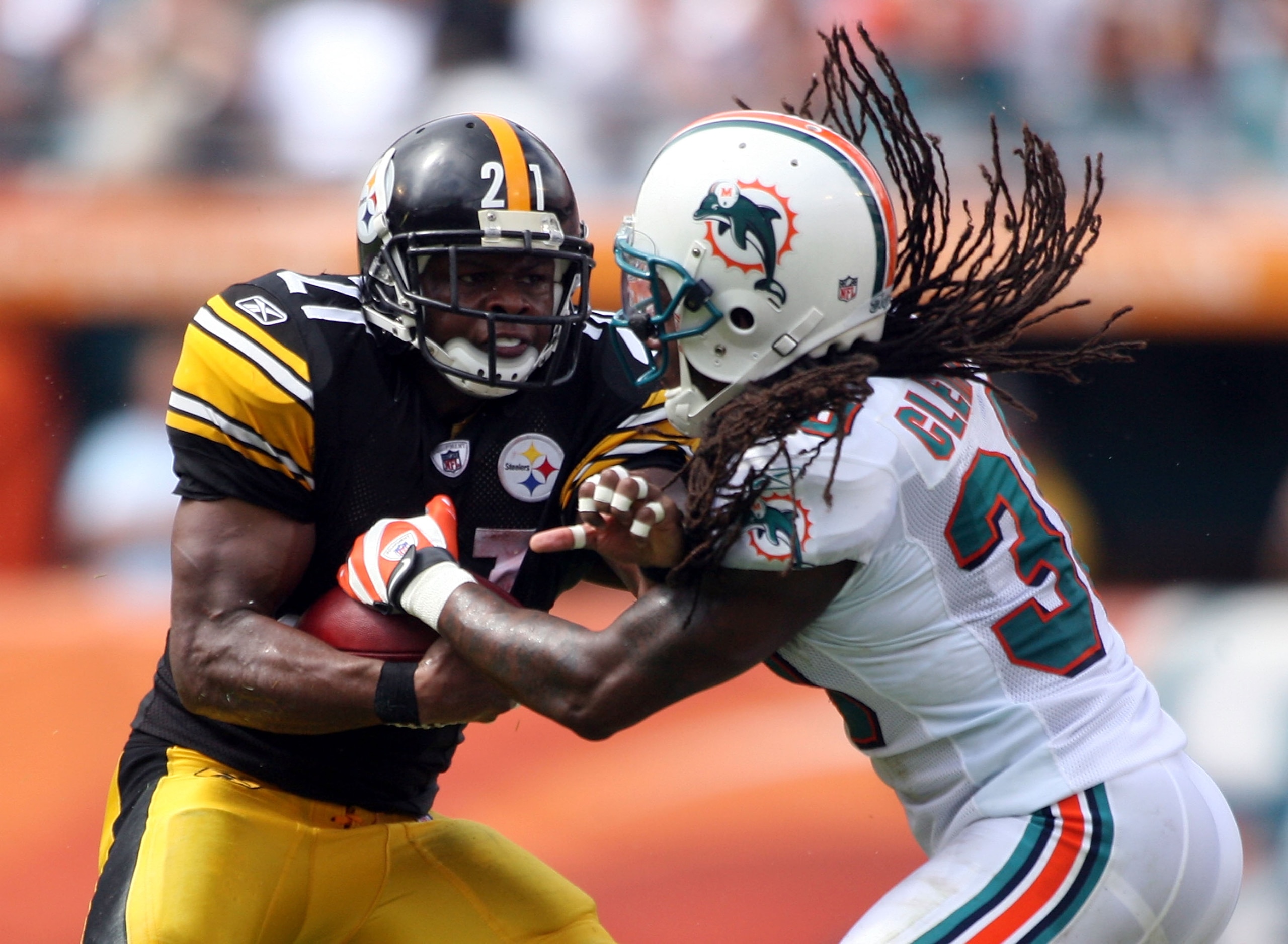 MIAMI - OCTOBER 24:  Running back Mewelde Moore #21  is tackled by safety Chris Clemons #30  of the Miami at Sun Life Stadium on October 24, 2010 in Miami, Florida.  (Photo by Marc Serota/Getty Images)