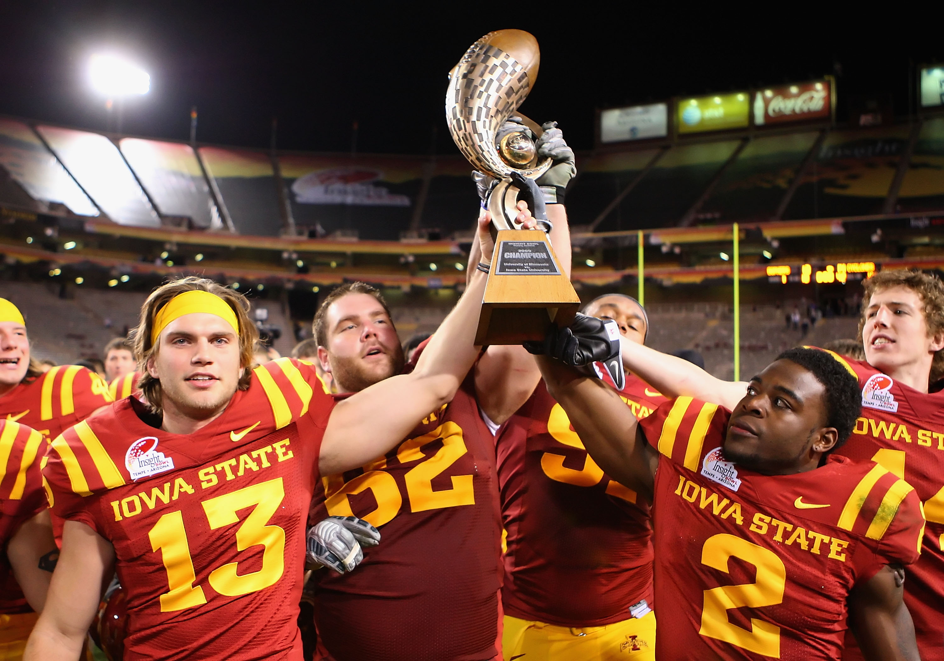 TEMPE, AZ - DECEMBER 31:  (L-R)  Mike Brandtner #13, Nate Frere #62 and James Smith #2 of the Iowa State Cyclones celebrate with the Insight Bowl trophy after defeating the Minnesota Golden Gophers at Arizona Stadium on December 31, 2009 in Tempe, Arizona