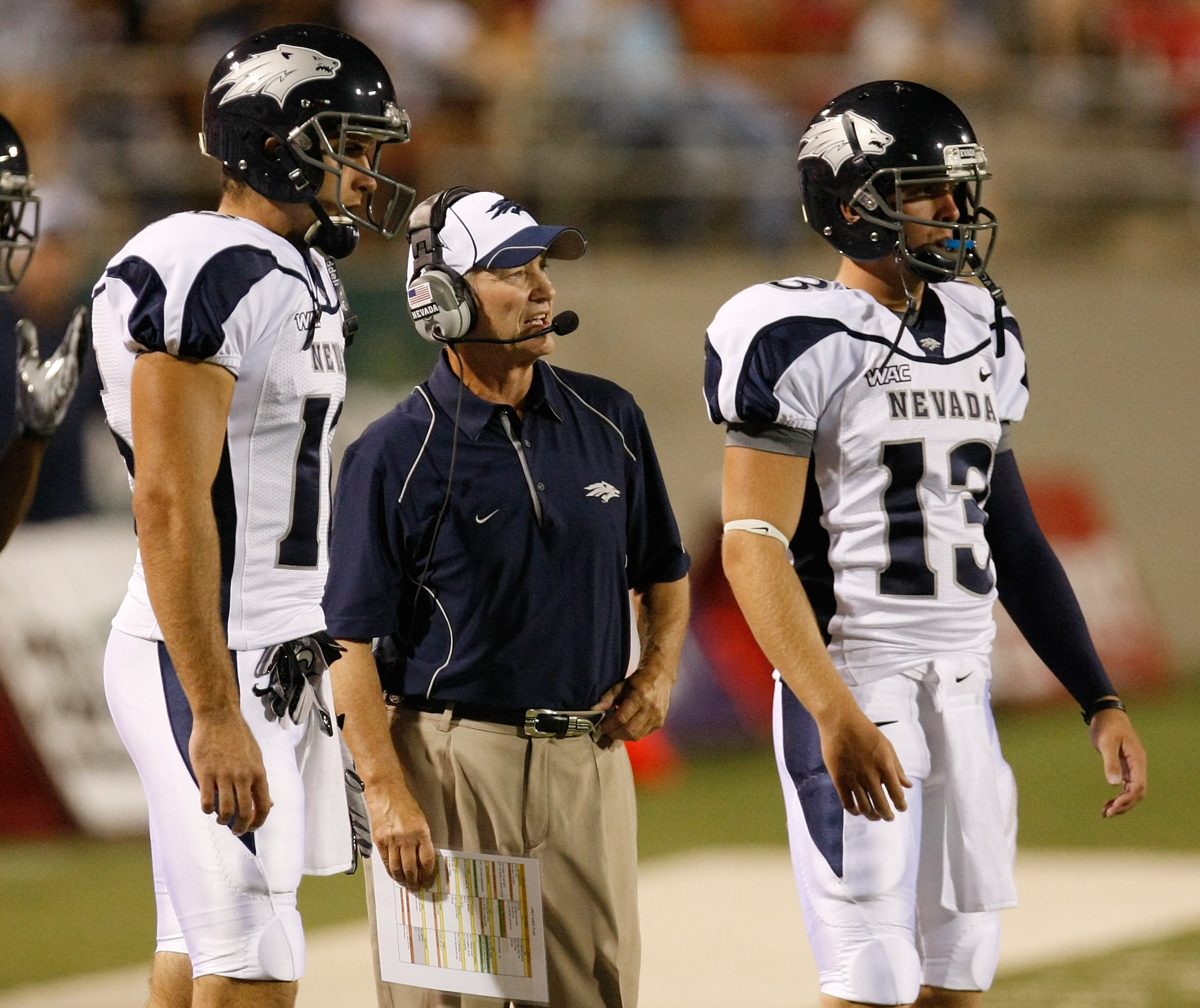 LAS VEGAS - OCTOBER 02:  Nevada Reno Wolf Pack head coach Chris Ault (C) is flanked by quarterbacks Tyler Lantrip #16 and Mason Magleby #13 as Ault watches his players take on the UNLV Rebels at Sam Boyd Stadium October 2, 2010 in Las Vegas, Nevada. Nevad