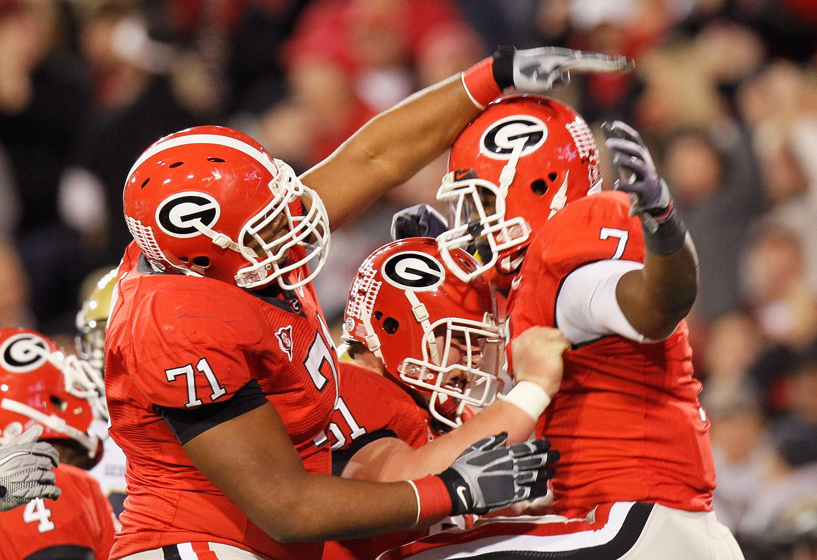 ATHENS, GA - NOVEMBER 27:  Cordy Glenn #71 and Ben Jones #61 of the Georgia Bulldogs celebrate with Orson Charles #7 after Charles touchdown against the Georgia Tech Yellow Jackets at Sanford Stadium on November 27, 2010 in Athens, Georgia.  (Photo by Kev