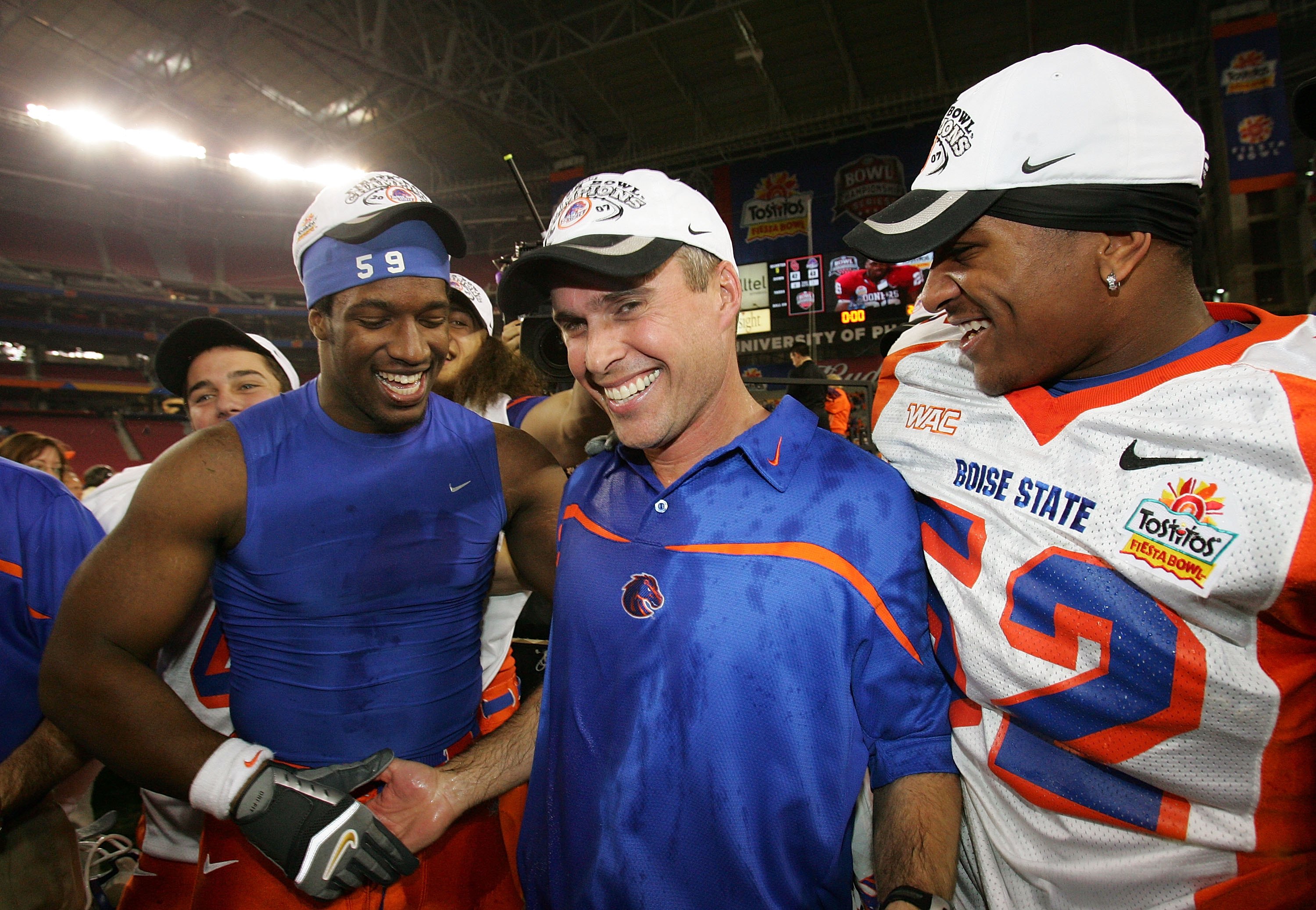 GLENDALE, AZ - JANUARY 1:  Head coach Chris Petersen of the Boise State Broncos is hugged by Will Lawrence #59 and Derrell Acrey after defeating the Oklahoma Sooners 43-42 at the Tostito's Fiesta Bowl against the Boise State Broncos at University of Phoen