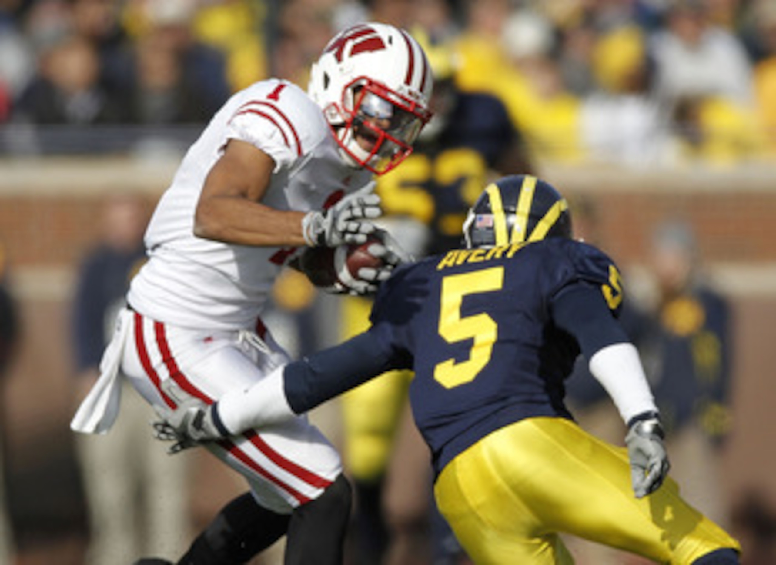 ANN ARBOR, MI - NOVEMBER 20:  Nick Toon #1 of the Wisconsin Badgers tries to get around the tackle of Courtney Avery #5 of the Michigan Wolverines at Michigan Stadium on November 20, 2010 in Ann Arbor, Michigan.  (Photo by Gregory Shamus/Getty Images)